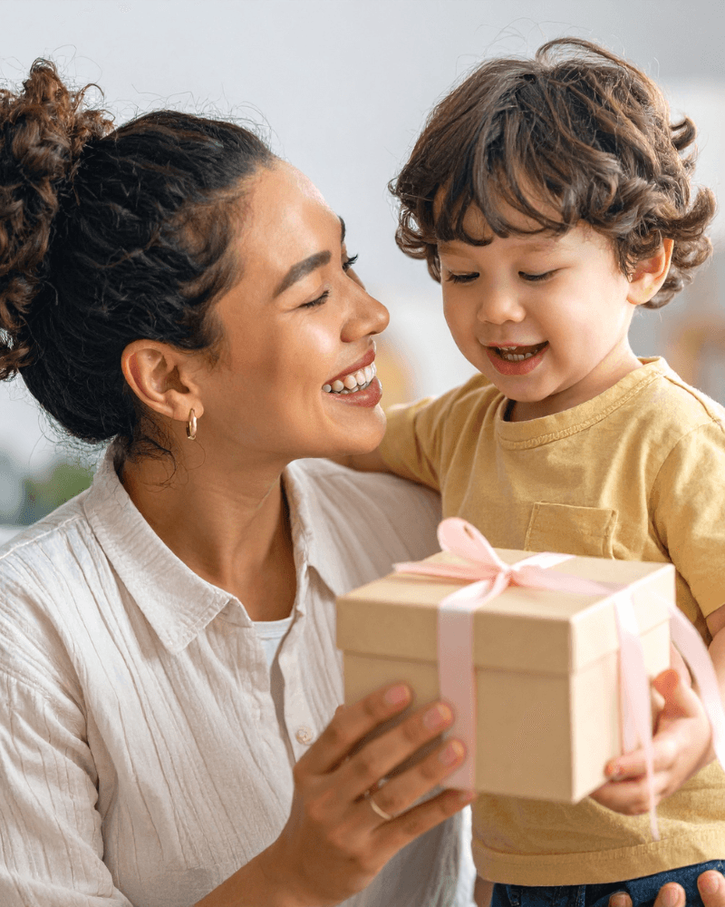 Woman smiling and relaxing in a bright classroom setting, showing the benefit of **less financial stress