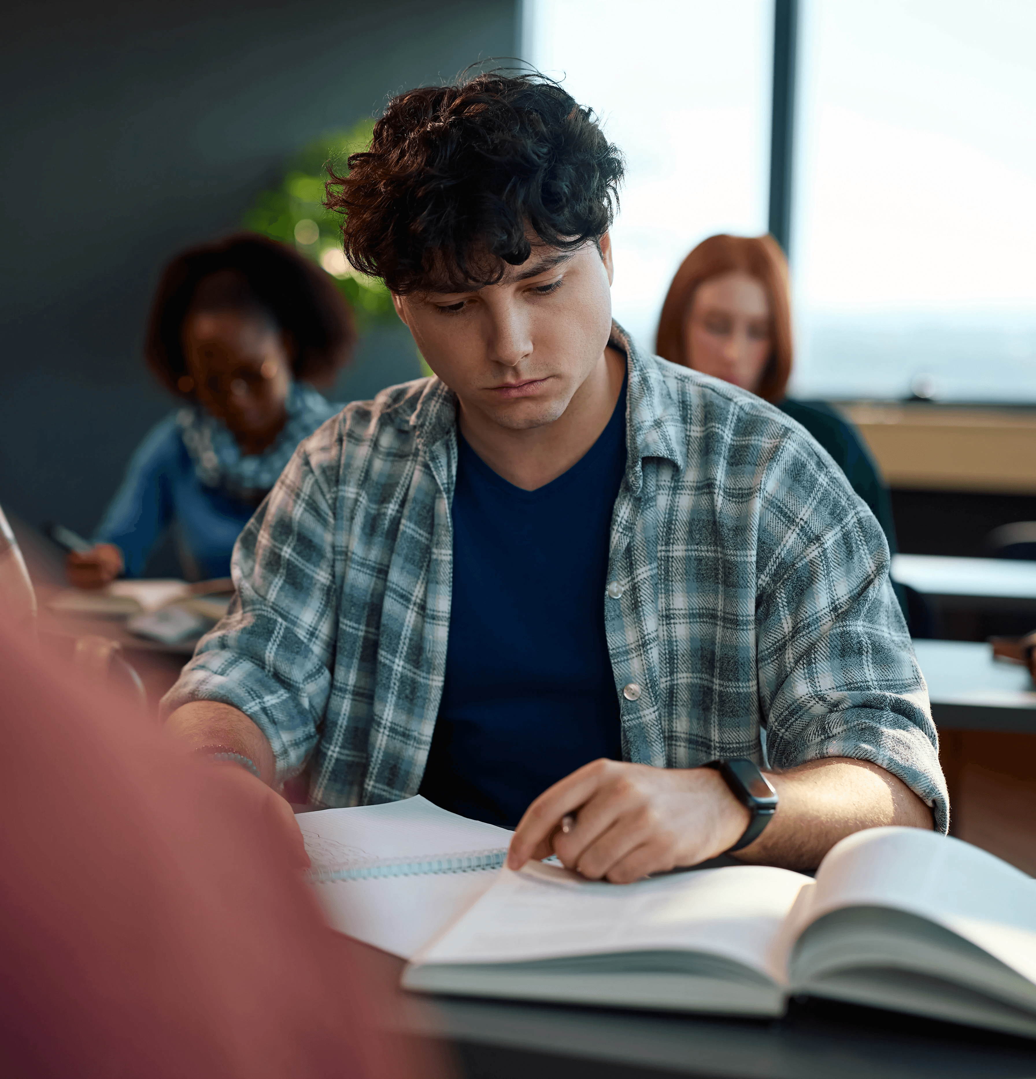A student wearing a yellow t-shirt sits with a calm expression