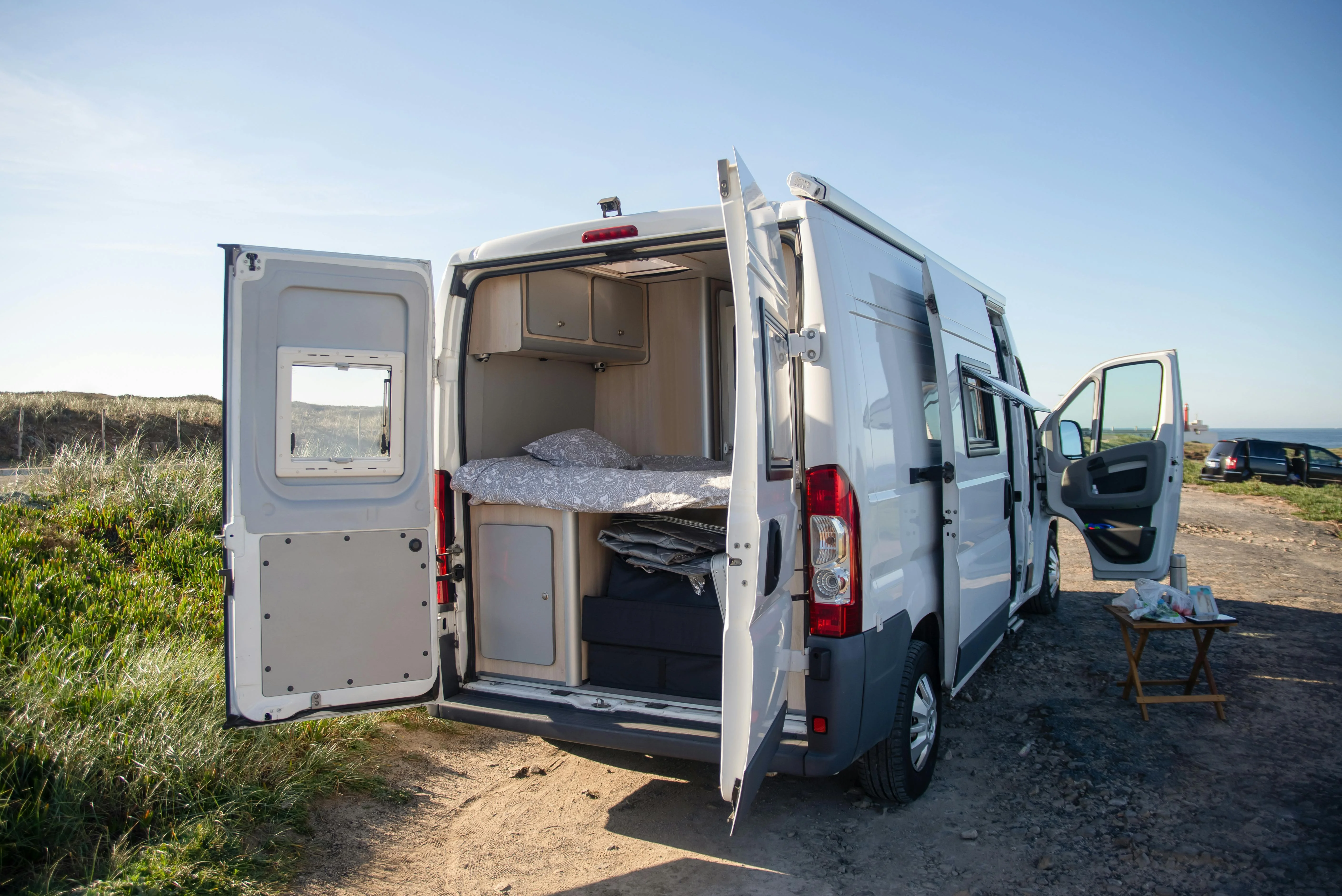 Un van aménagé ouvert sur la mer, parfait pour des escapades libres et confortables en bord de plage.