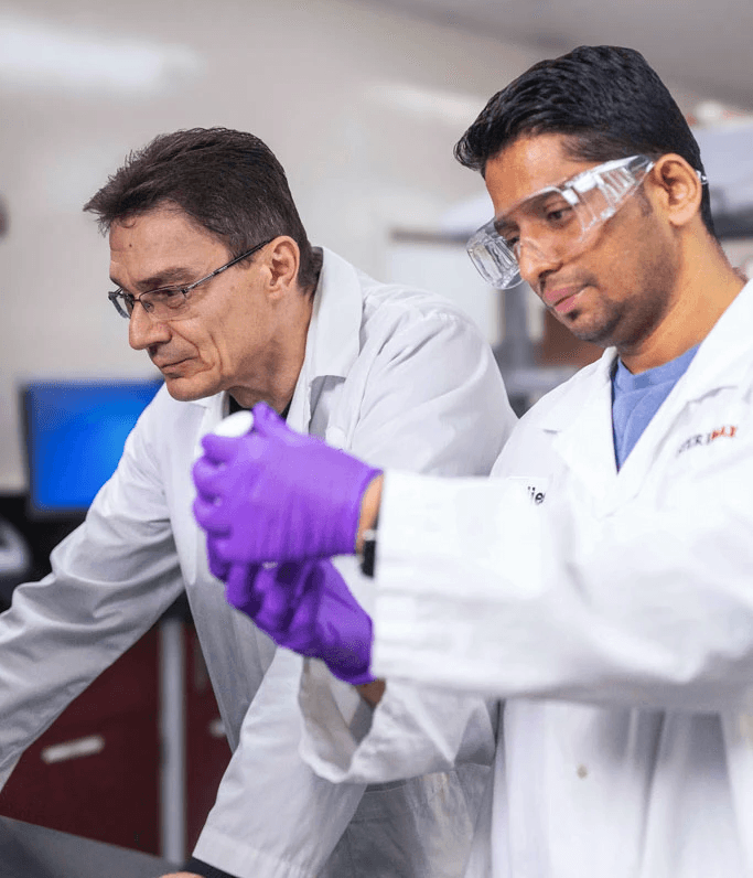 Two SteriMax scientists working together to examine a pharmaceutical sample in a laboratory.