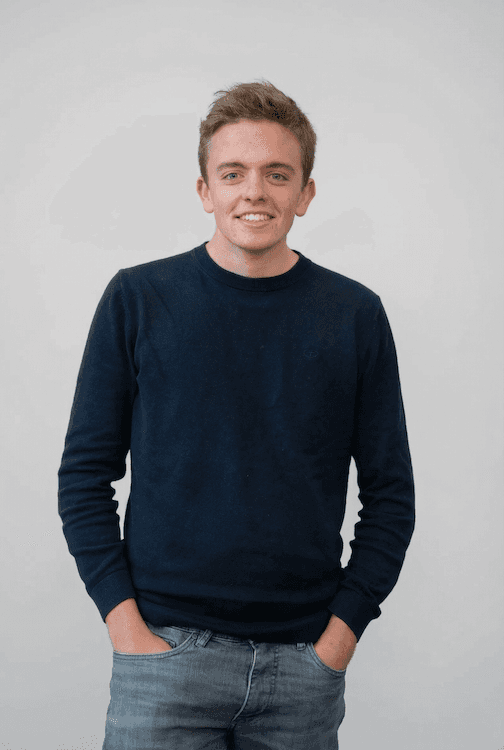 Portrait of a person in a pink sweater against a light background