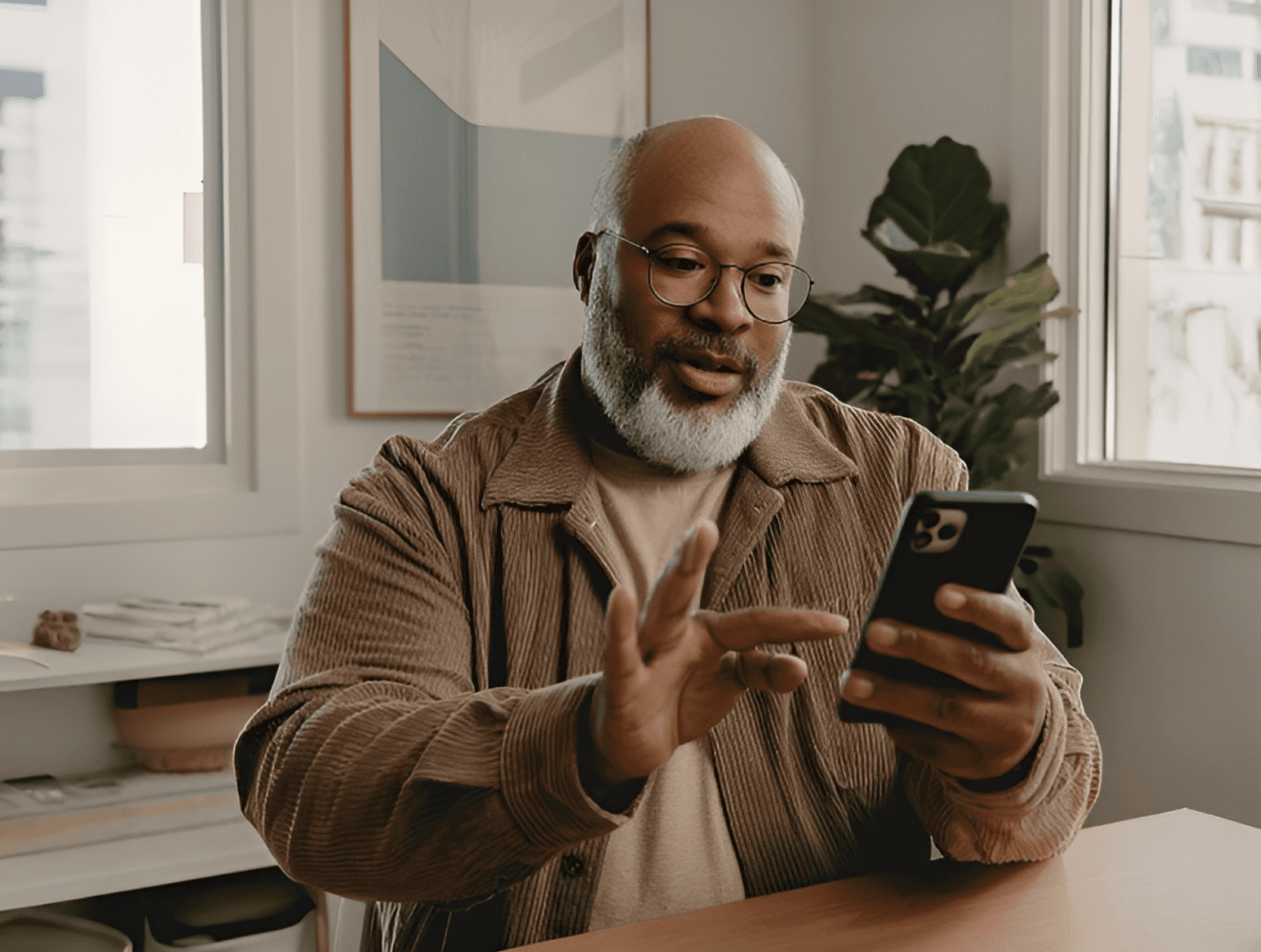A male patient in thoughts looking at his device.