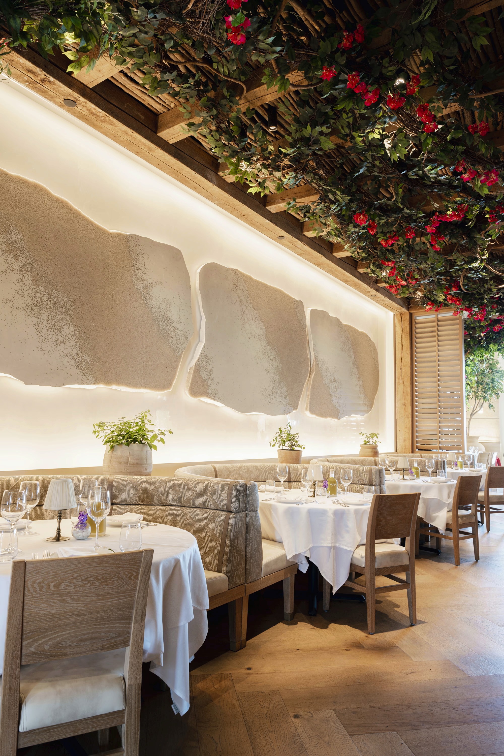 A cozy restaurant interior featuring white tablecloths, modern decor, and soft lighting.