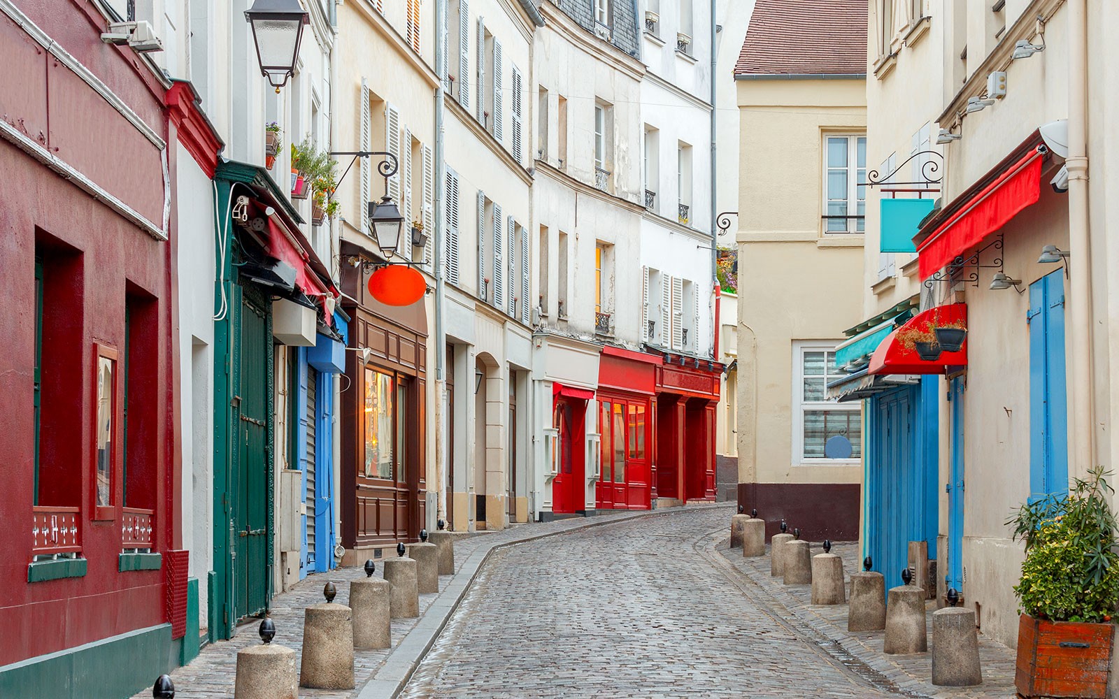 Calle adoquinada con coloridas fachadas de tiendas en París, parte de un tour gastronómico guiado.