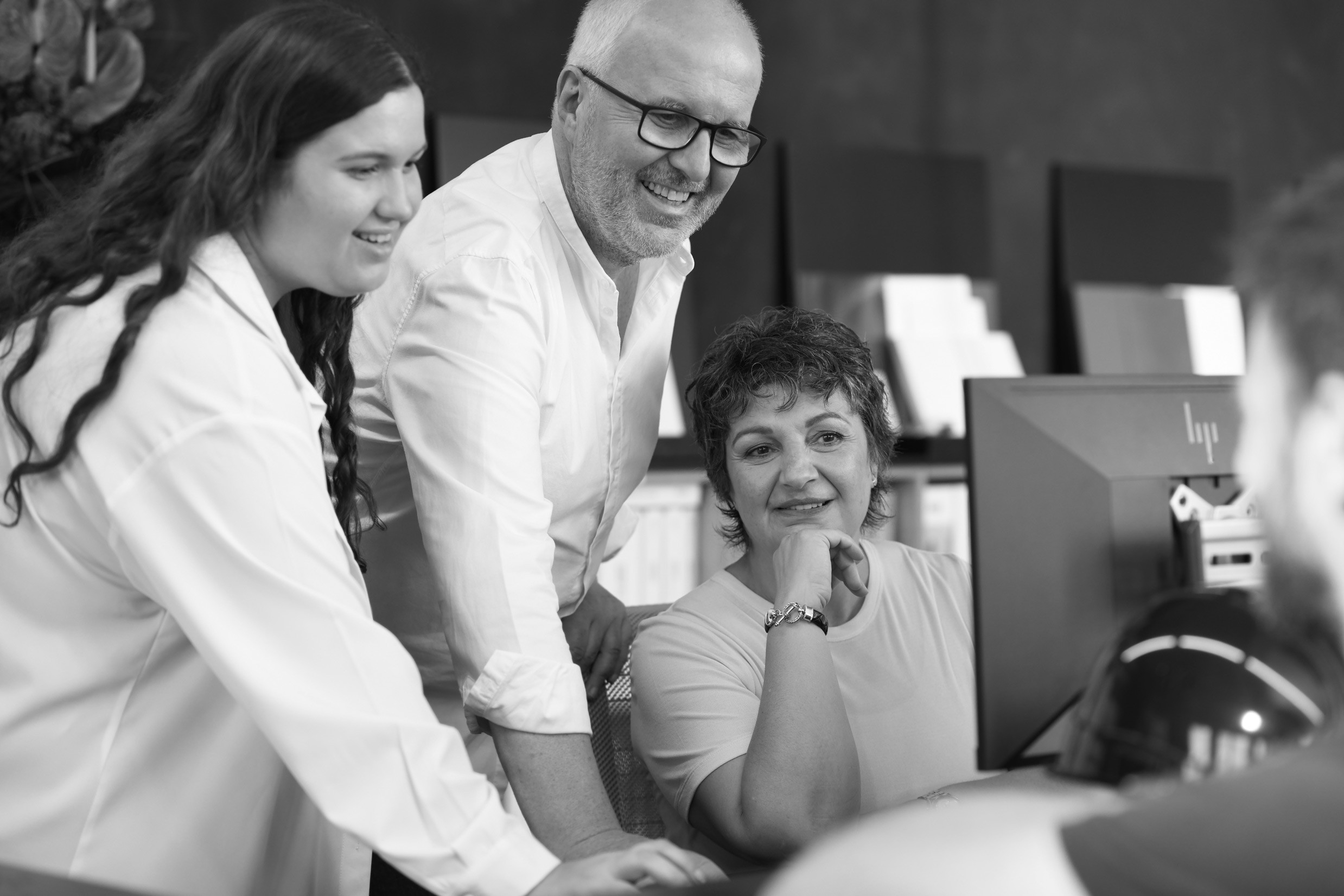 Drei Kollegen sichten Projekt am Computer