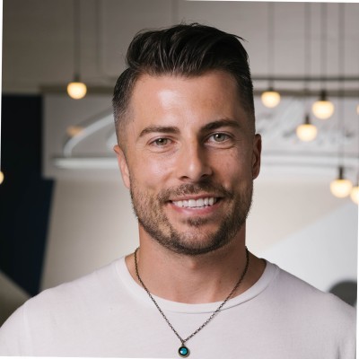 Profile portrait of a man in a white shirt against a light background