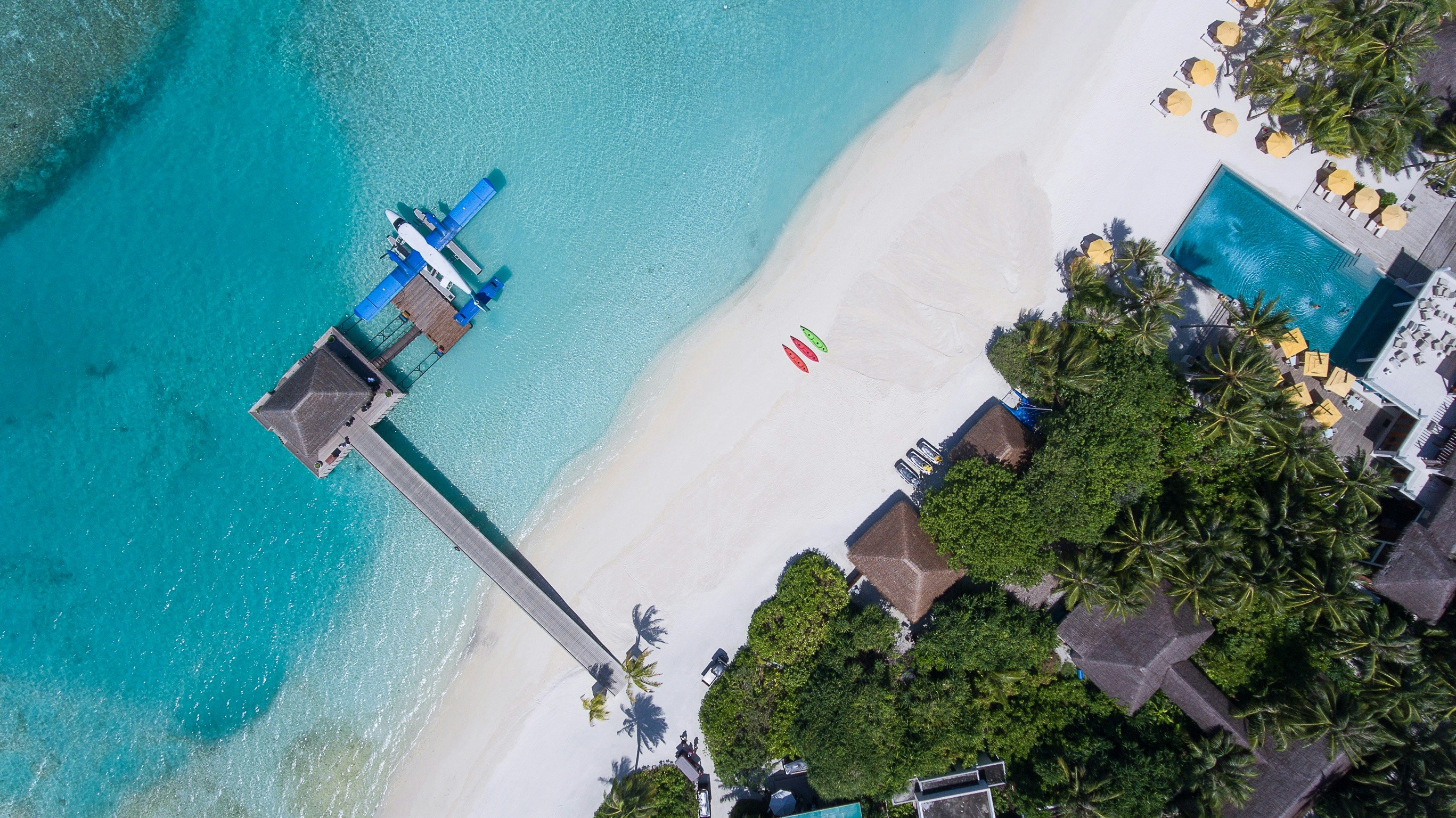 gray wooden dock in sea near trees at daytime. Credit: Ishan @seefromthesky