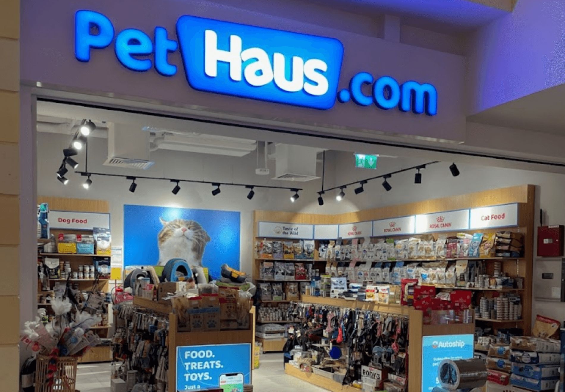 The Pet Haus store with a wide, open entryway and shelves full of pet food, pet accessories, and other pet products. 
