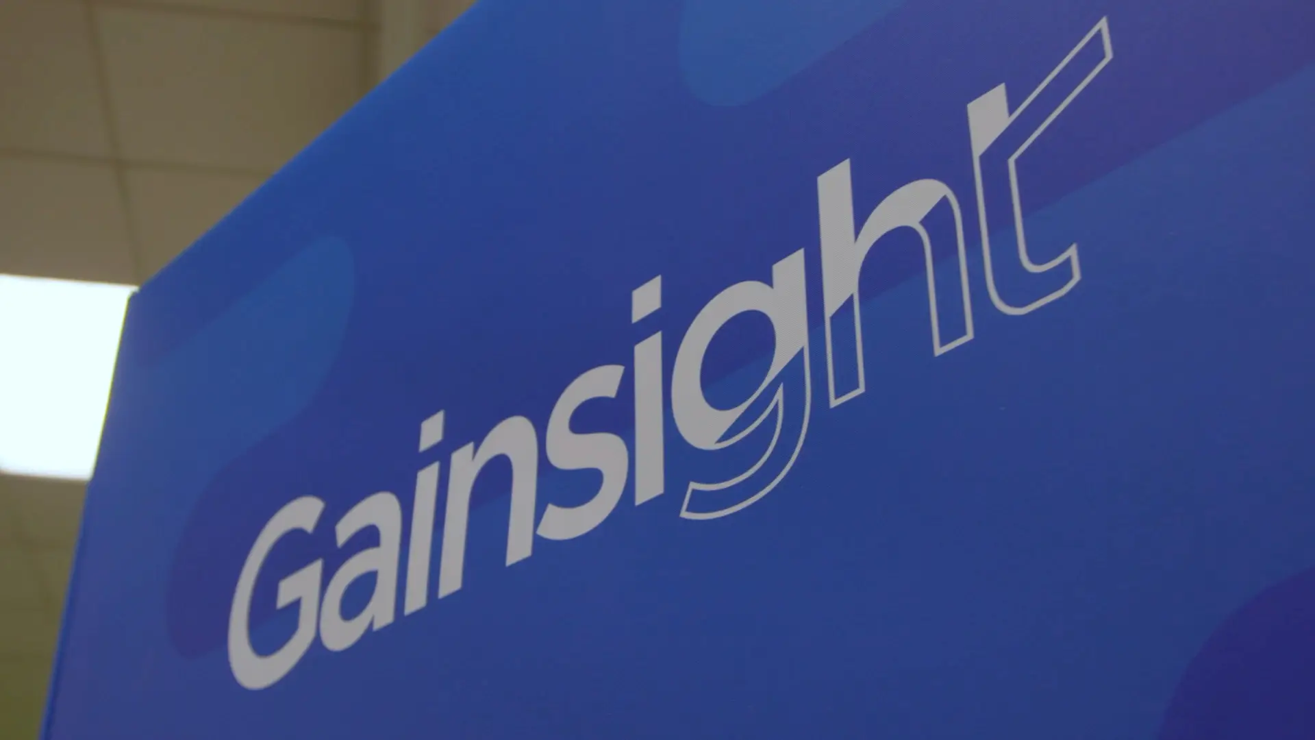 Close-up of Gainsight branding displayed on a large blue event backdrop.