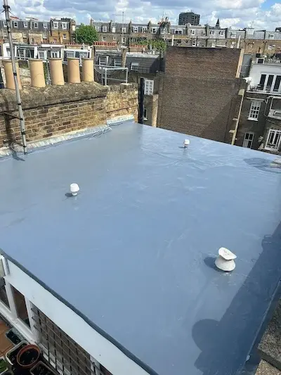 Newly installed flat roof with grey waterproof membrane on a residential building in London.
