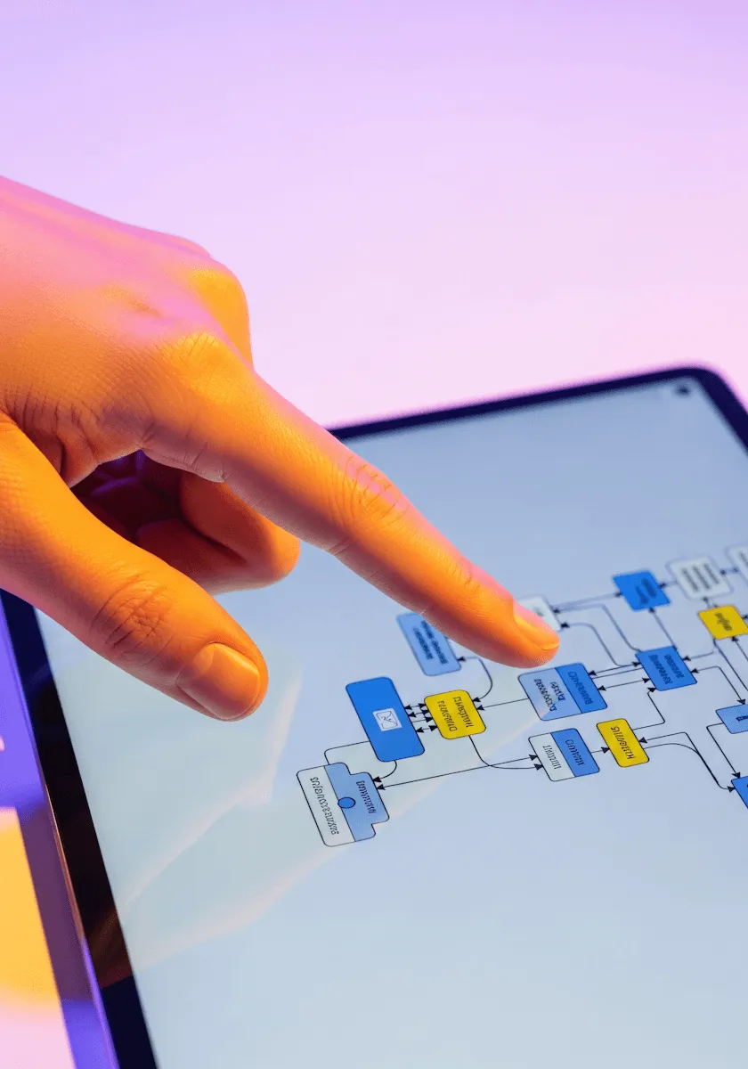 A hand pointing at a digital tablet screen displaying colorful interconnected nodes or data points.