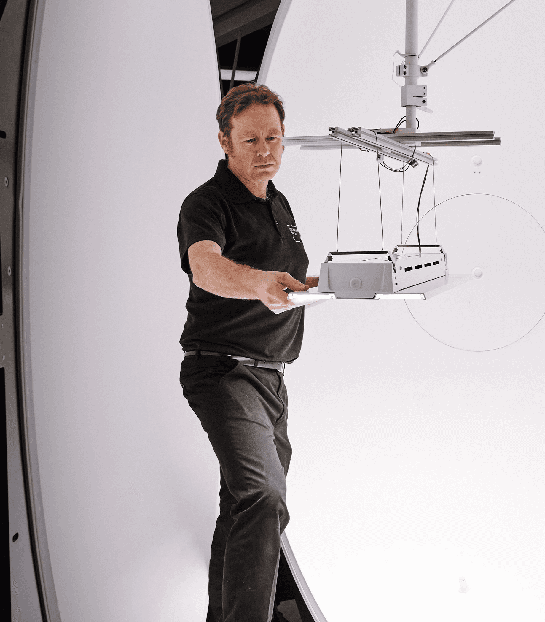 Modern glass and steel building with warm wooden ceilings, surrounded by lush greenery, blending contemporary architecture with nature.