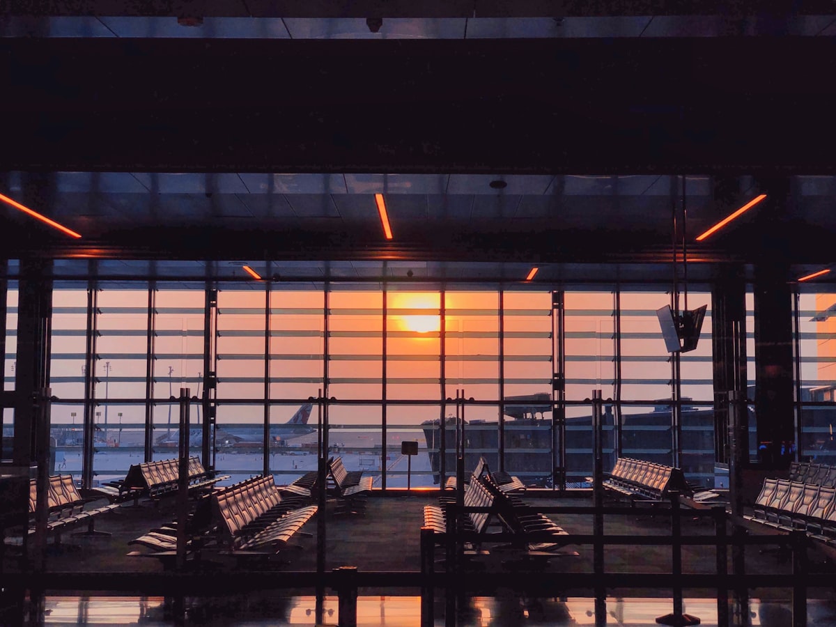 Golden hour light through airport windows as planes wait outside