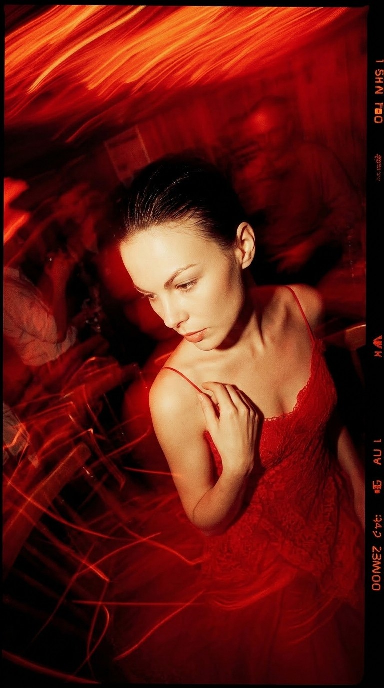 High-energy candid shot of a woman in red under low light