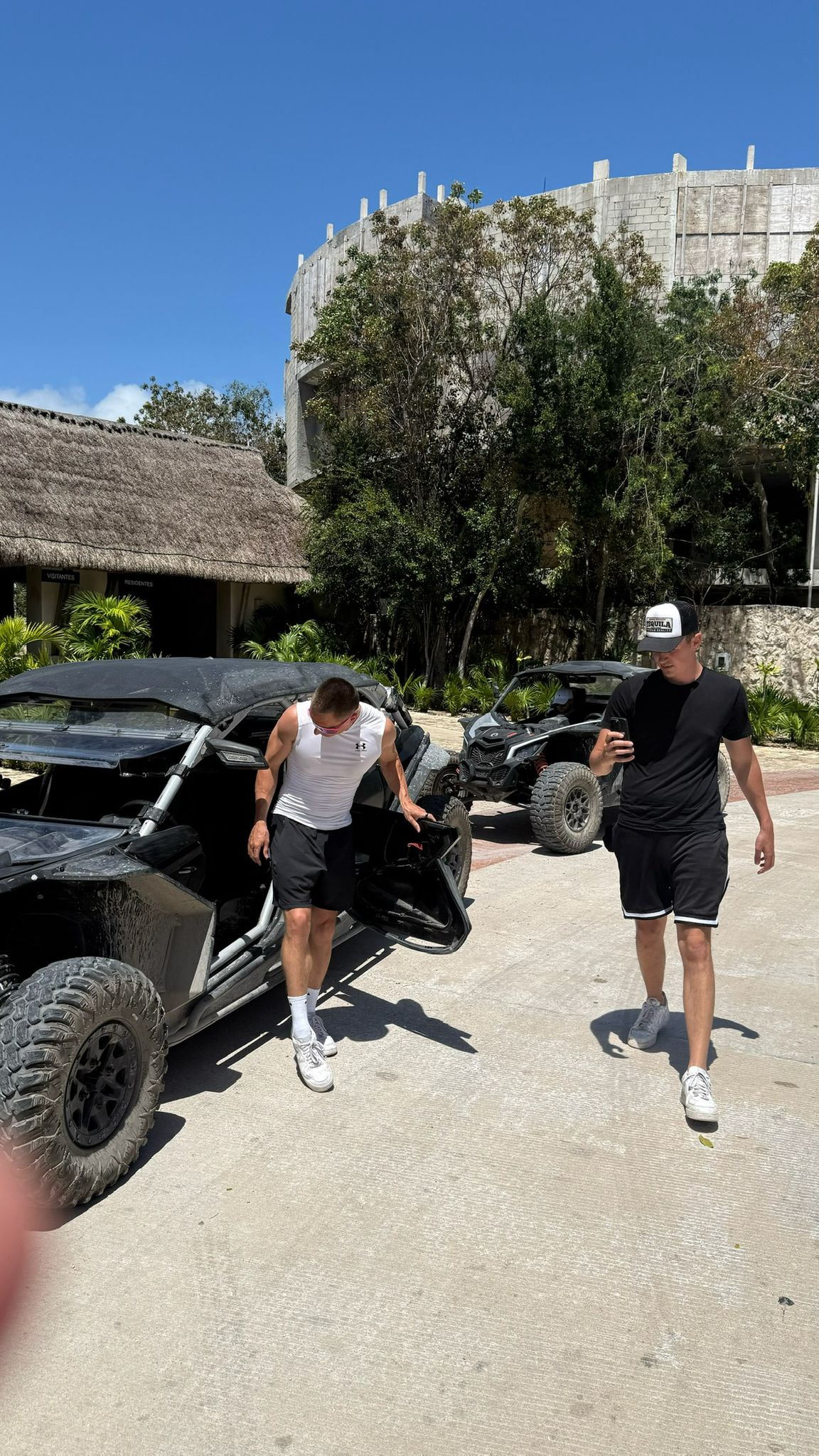 Two happy men driving a sportscar with a joyful expression, ideal for car rental adventure promotions.