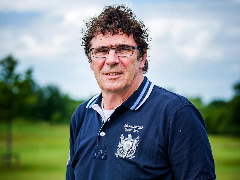 A person wearing glasses standing in a field.