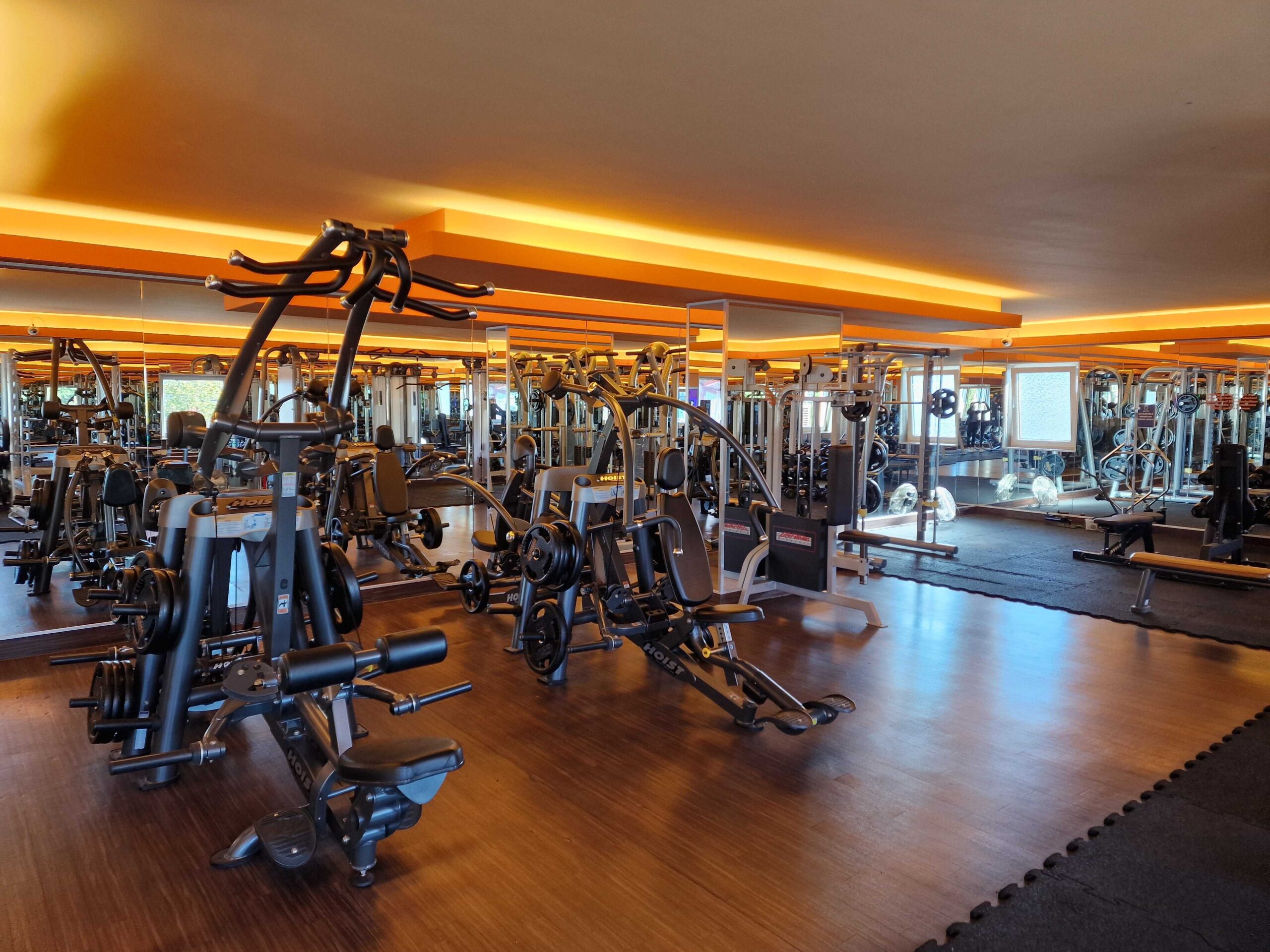 Red wooden harbor house overlooking boats, water, and snow-capped mountains.