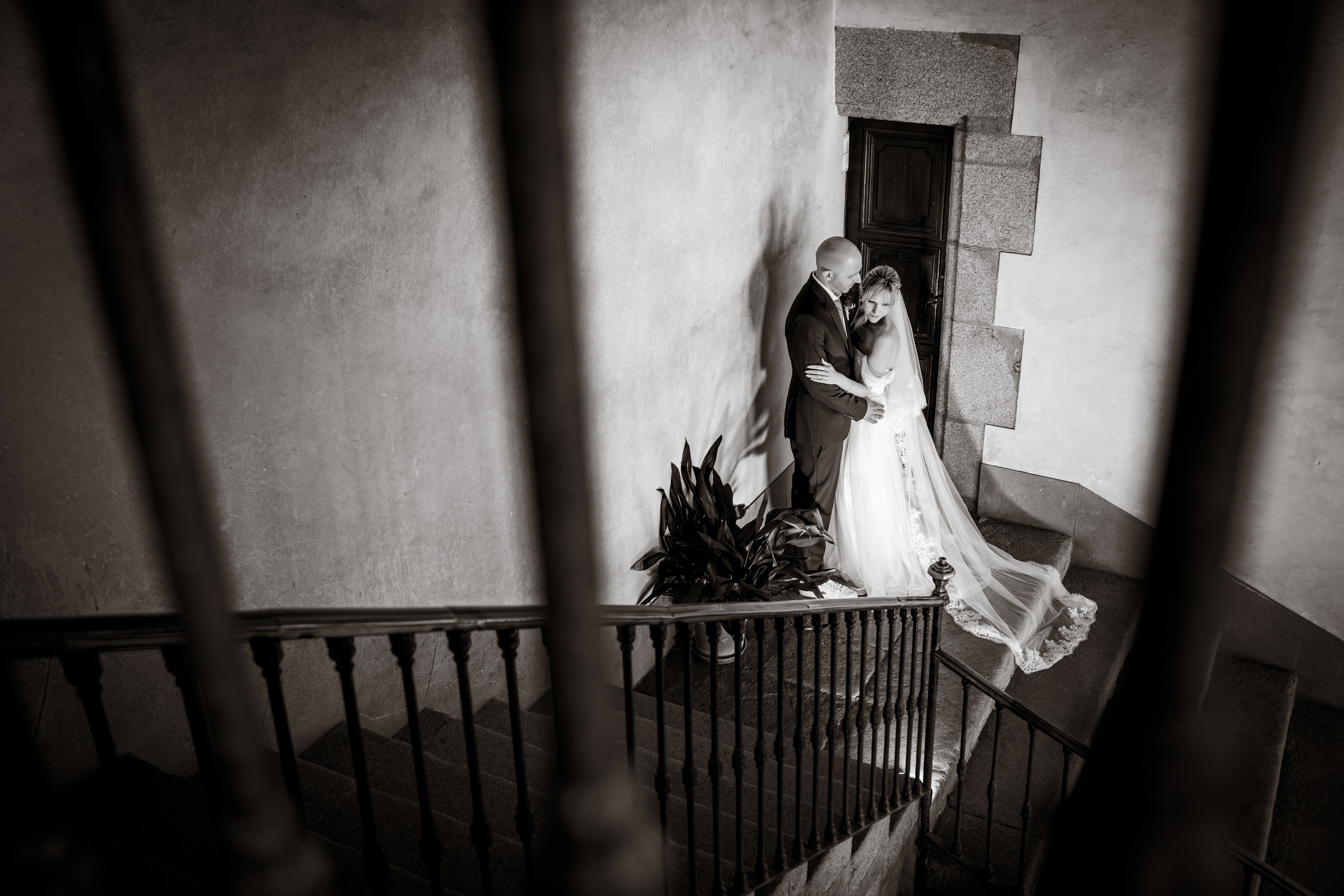 Sesión de boda en blanco y negro. Estan en una escalera abrazándose