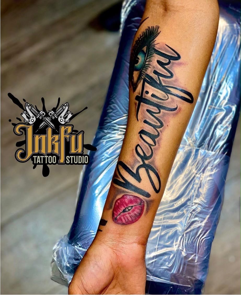Black script lettering reading Beautiful with a color eye and lips on the forearm, by Meer Rich
