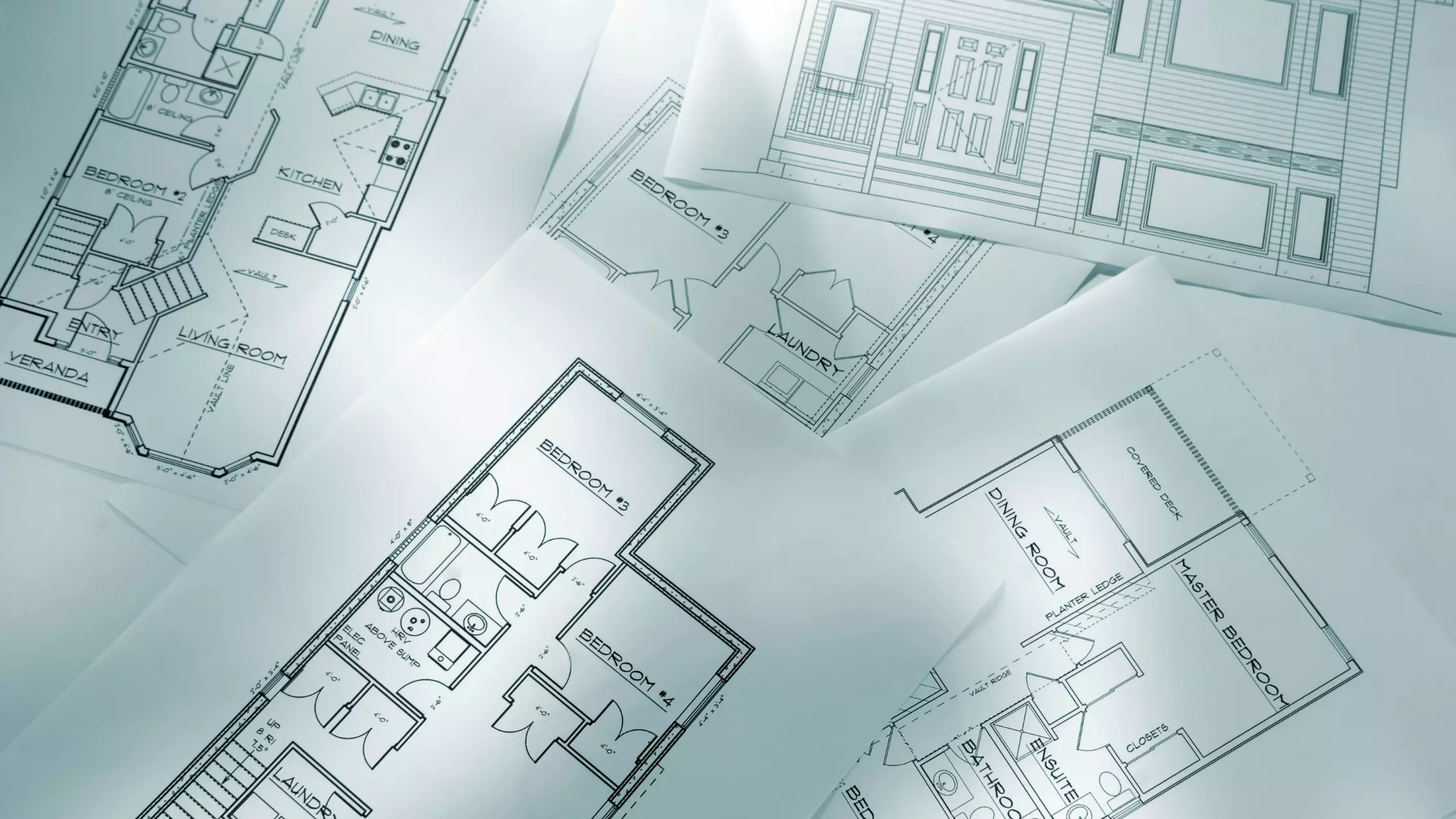 A man stands while two people sit at a table in an office setting, smiling and engaged in conversation. The mood is friendly and collaborative.