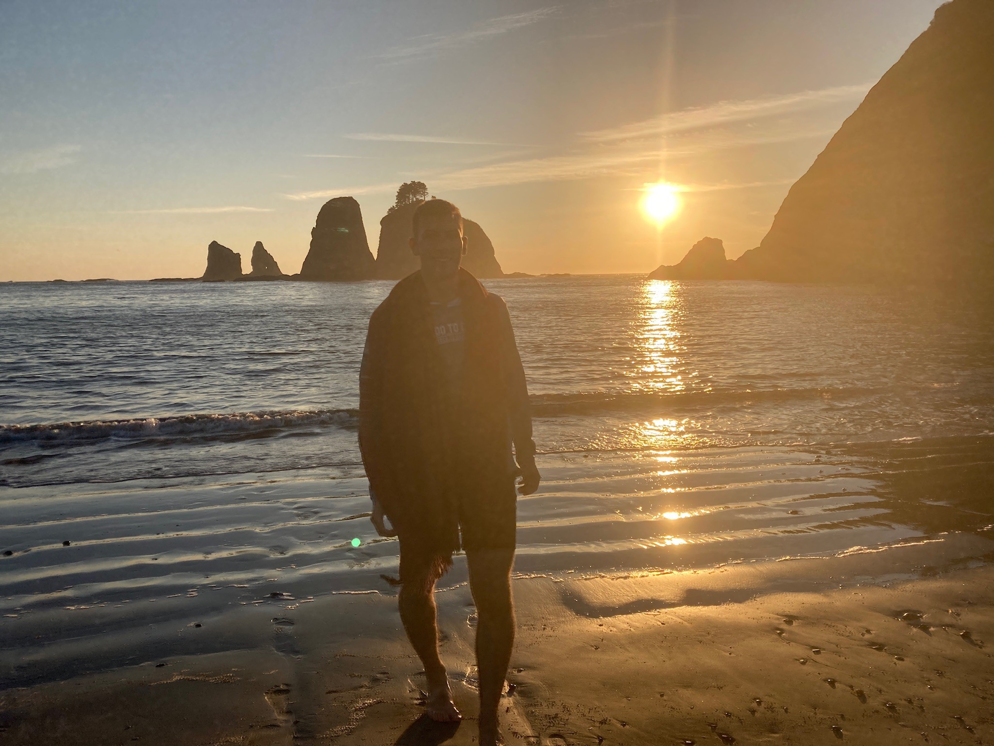 An image of me walking on a rocky beach while the sun sets.