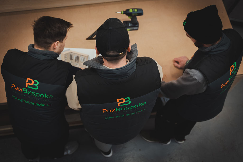 three men looking at a printed wardrobe rendering