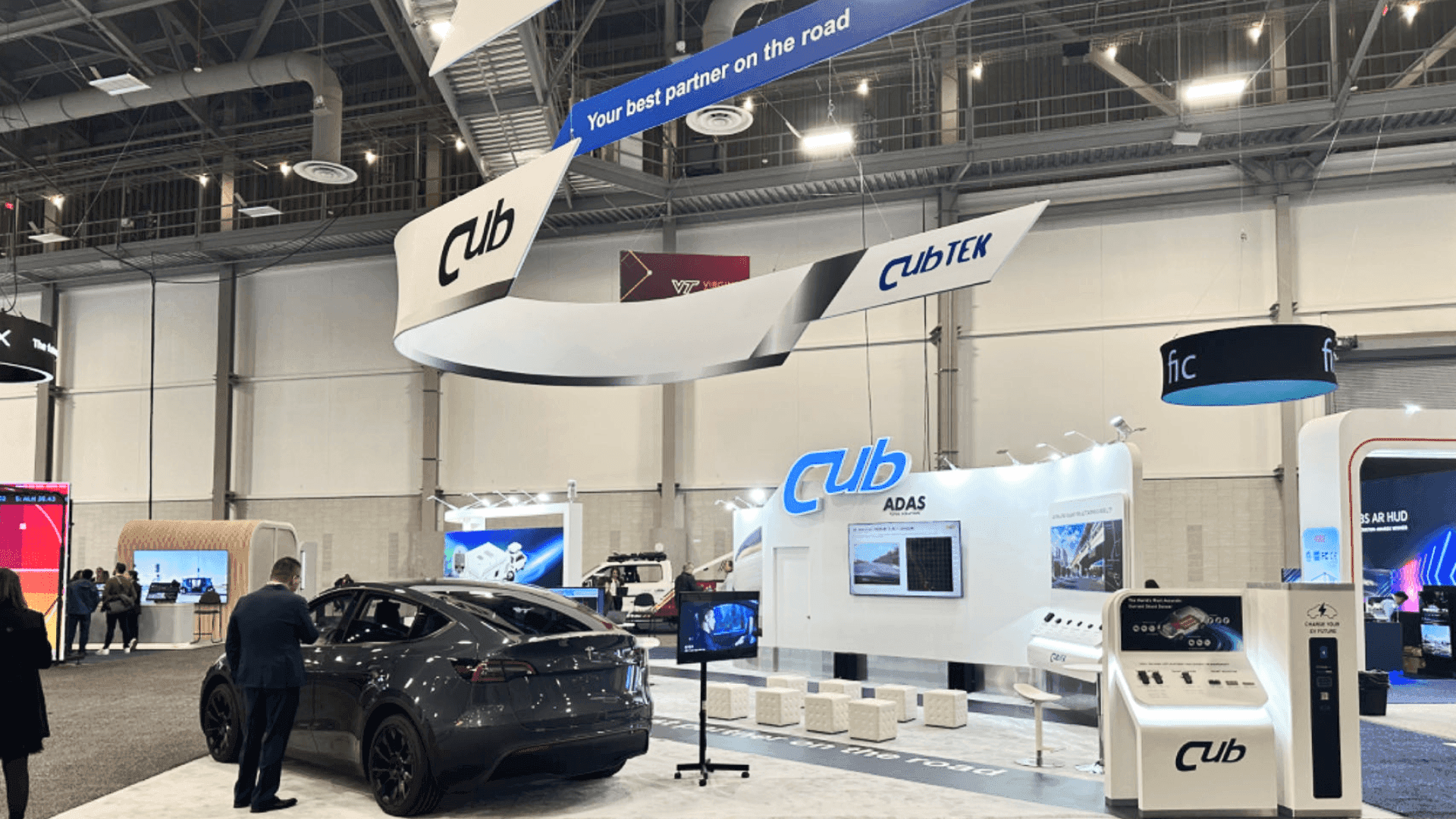 EV infrastructure exhibit booth featuring charging station presentation and integrated digital dashboard display