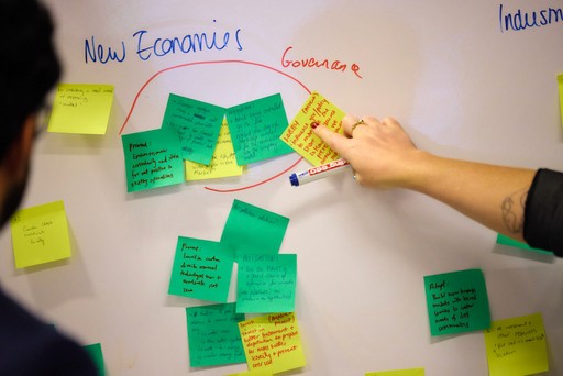 Close-up of a dark green leaf showing its textured surface and central vein against a muted background.