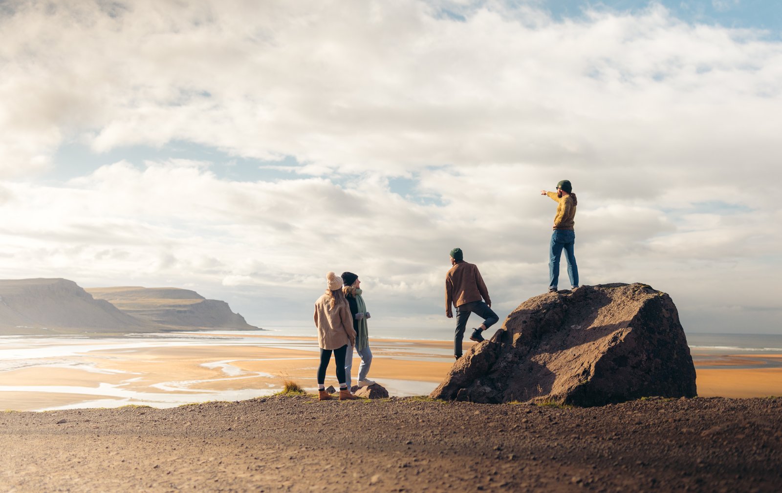 Vast sandy plain with scattered rocks and distant mountains beneath an overcast sky.
