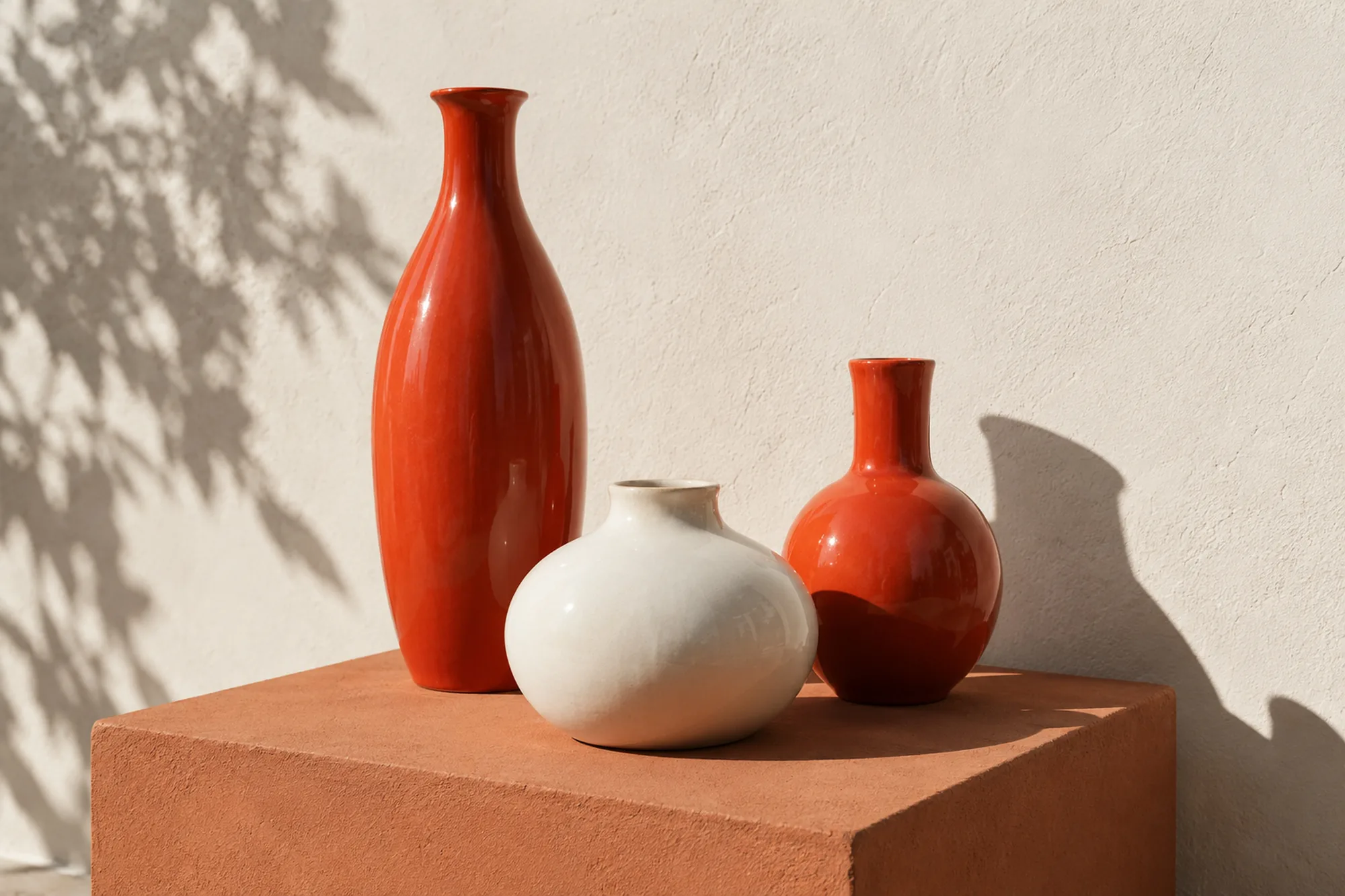 Red and bone ceramic vases on a terracotta plinth