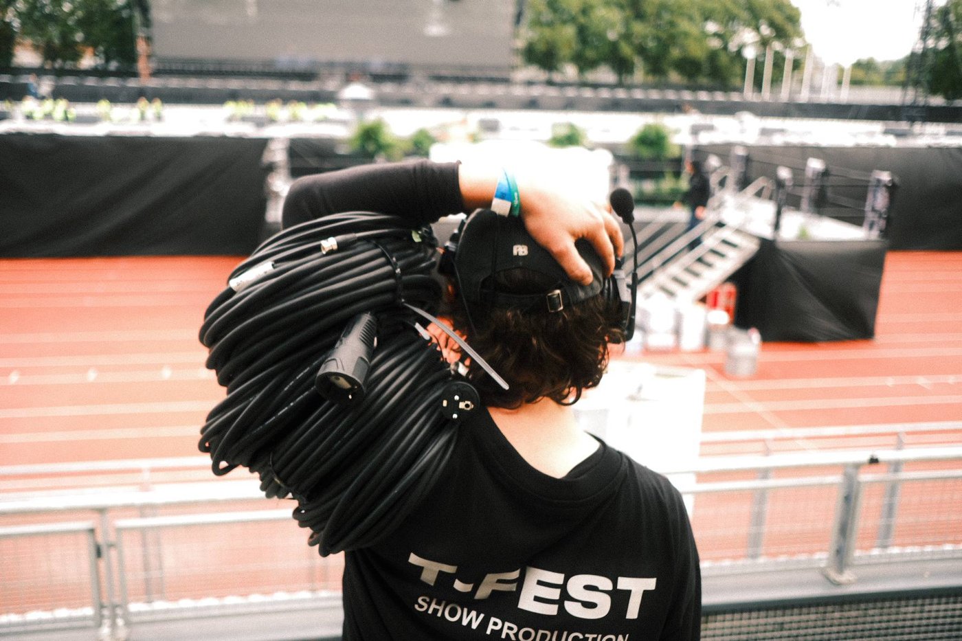 Crew member carrying camera cables at the stadium