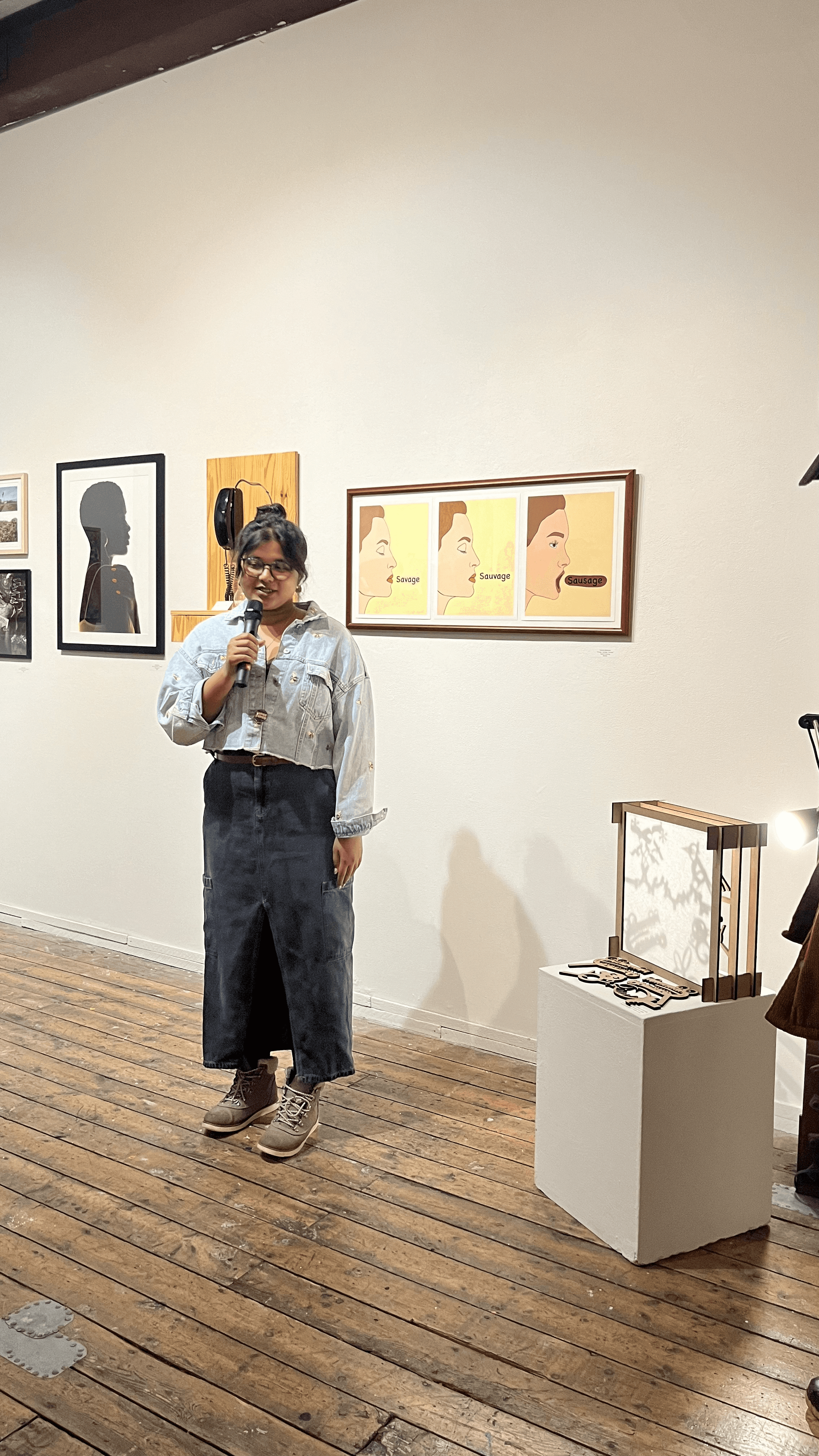 Black and white photo of two people looking at a computer screen with papers on wall