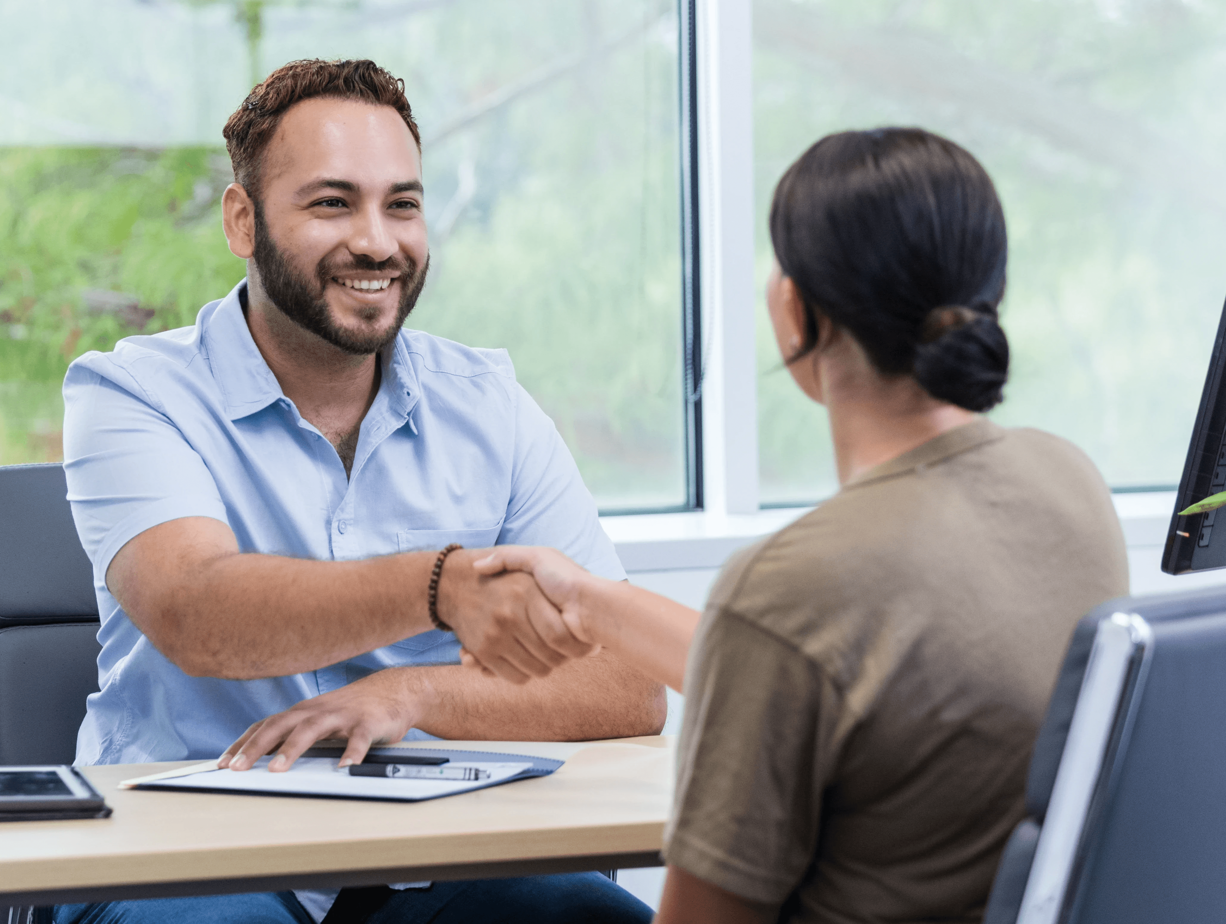 Person smiling while working on a laptop, with icons representing AI-powered research tools around