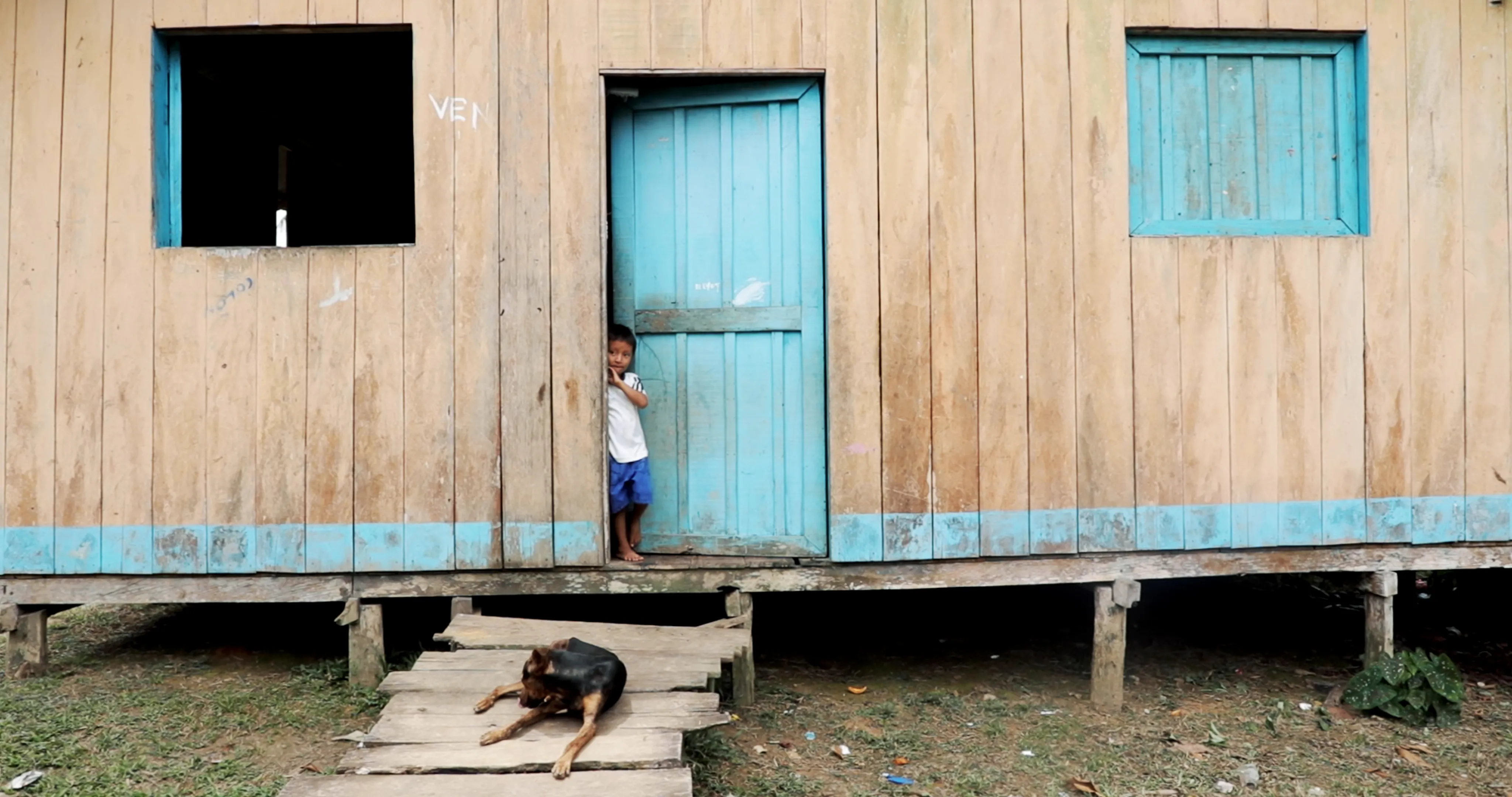 a little boy says hi from his door 