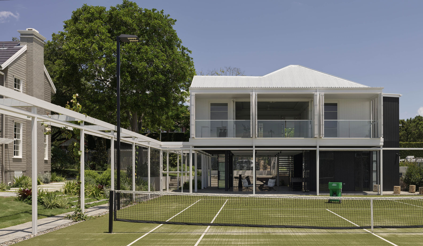 residential exterior with elevated pavilion and tennis court