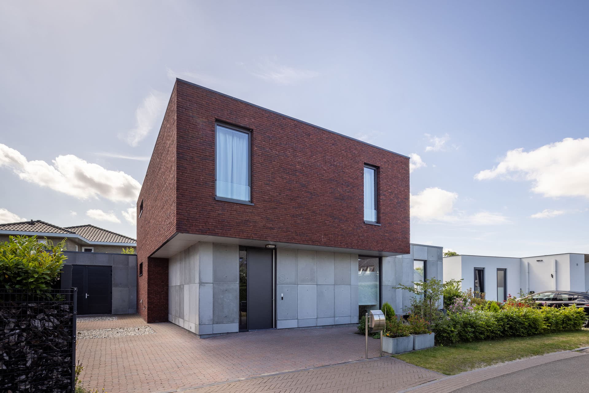 Moderne villa in Zonnehoeve Apeldoorn met lichte bakstenen gevel, grote glaspartijen en groene voortuin