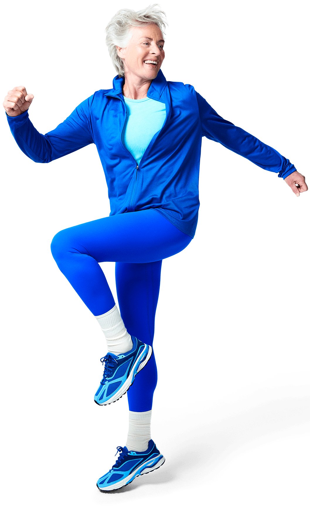 A person in a blue tracksuit is joyfully balancing on one foot with a playful expression.