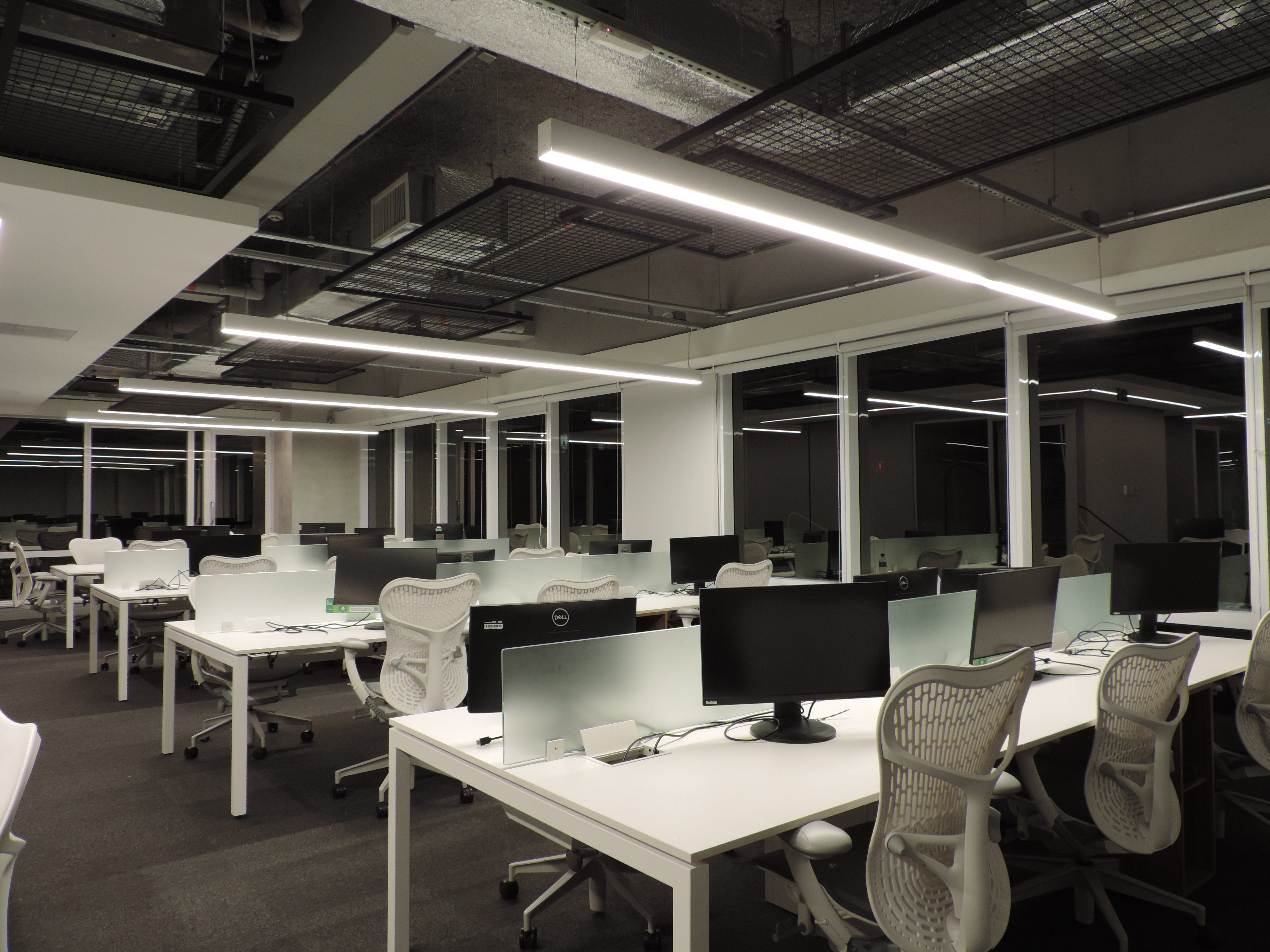 Beige interior with natural stone walls, sunlight, and geometric shadows over a calm water pool.
