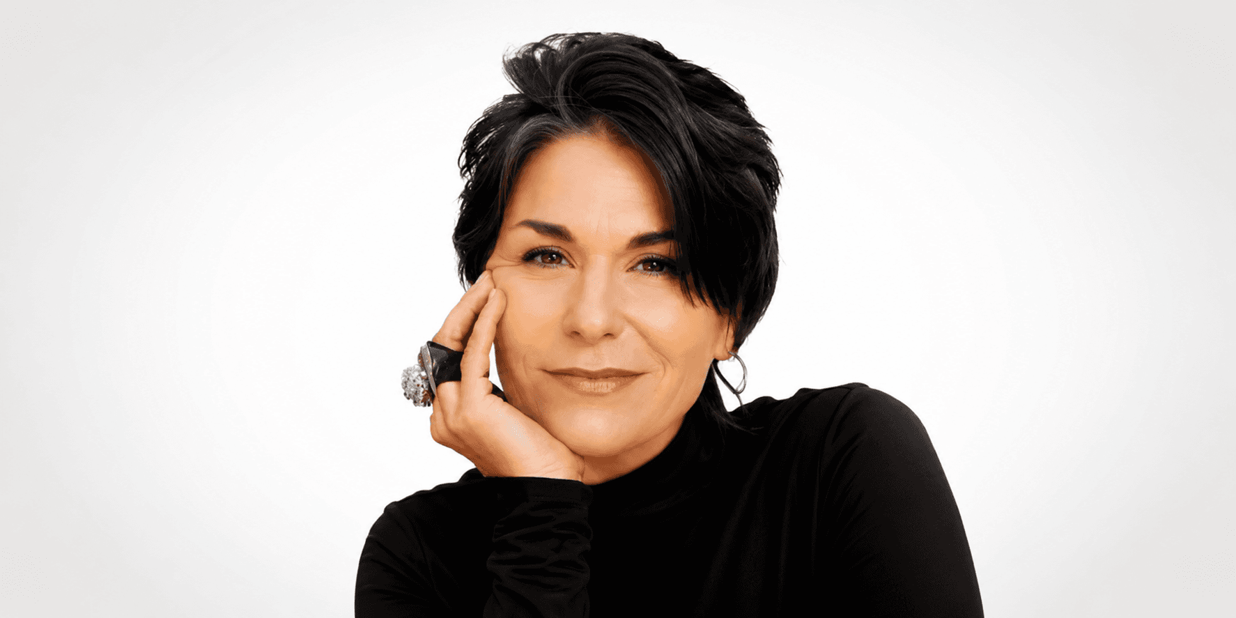 Debbi DiMaggio poses in a black top against a white background.