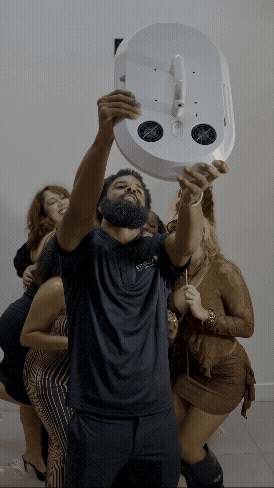 The Classic Photobooth by Studio 7 live at an event. The booth is illuminated through its ring lights with a screen saying 