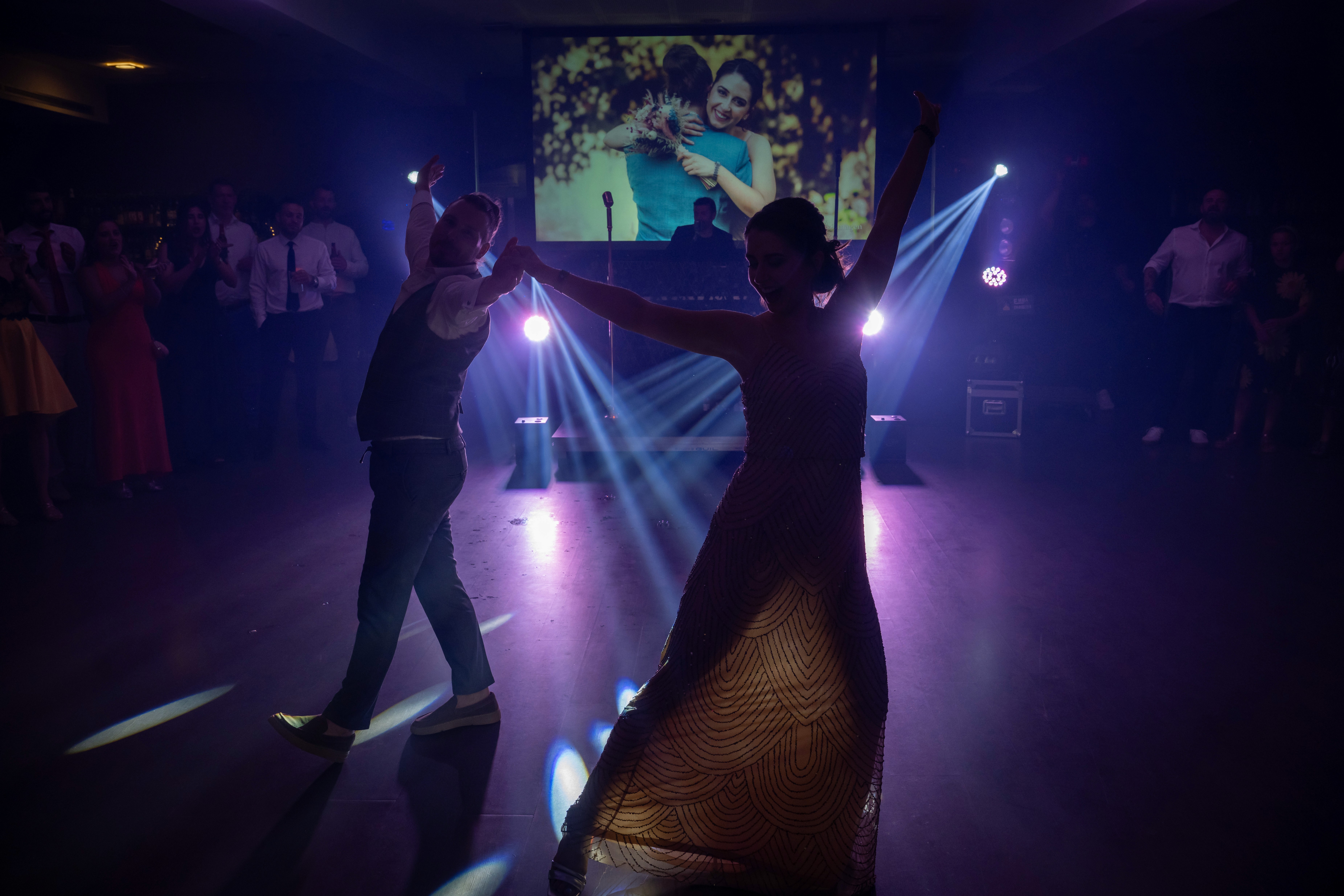 Personas bailando bajo luces violetas durante una fiesta
