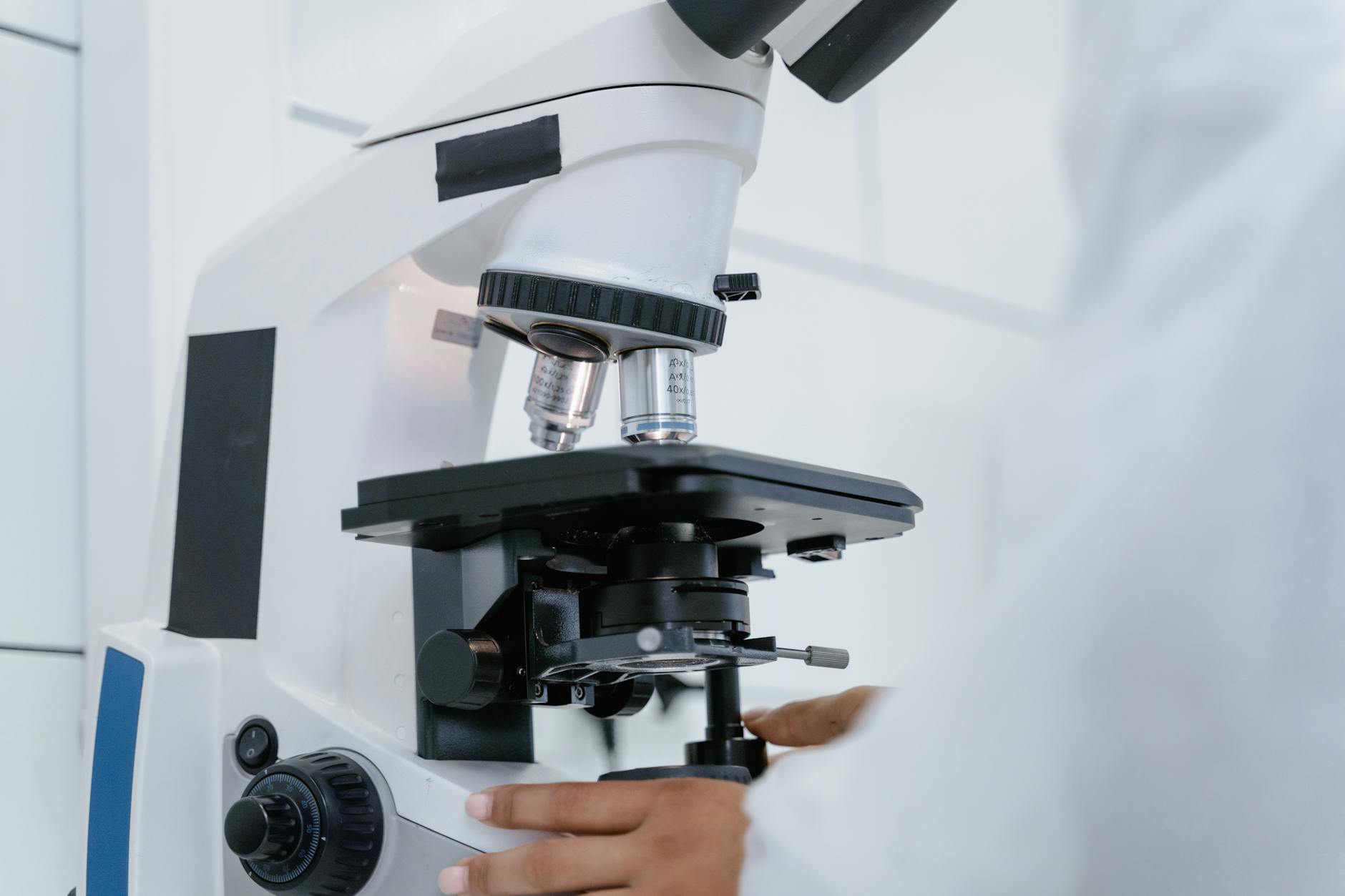 Close-up of a science teacher in a lab coat demonstrating a chemistry experiment to attentive high school students.