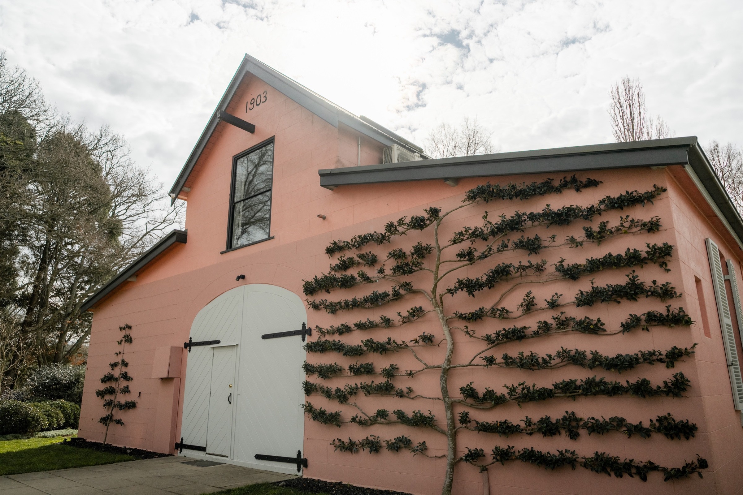 Pink Coach House building and espalier garden at Mona Farm in Braidwood