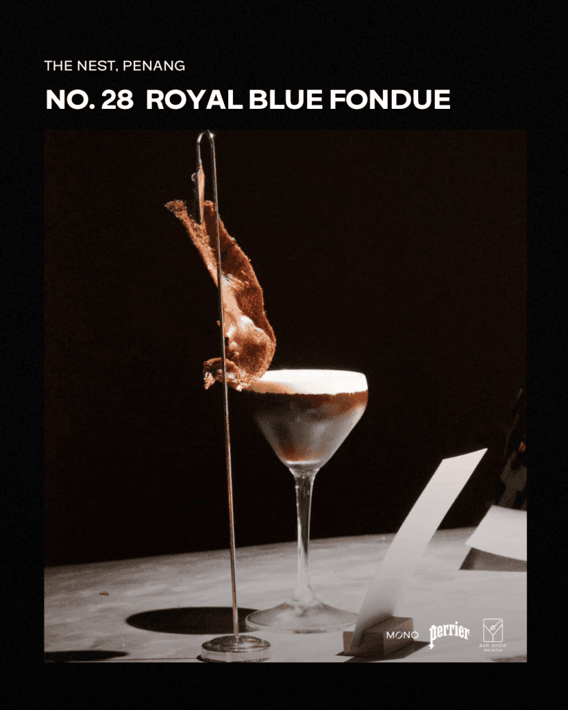 A sophisticated cocktail named 'Royal Blue Fondue' served in a stemmed glass, featuring a unique garnish. The drink is highlighted against a dark background, emphasizing its elegant presentation.