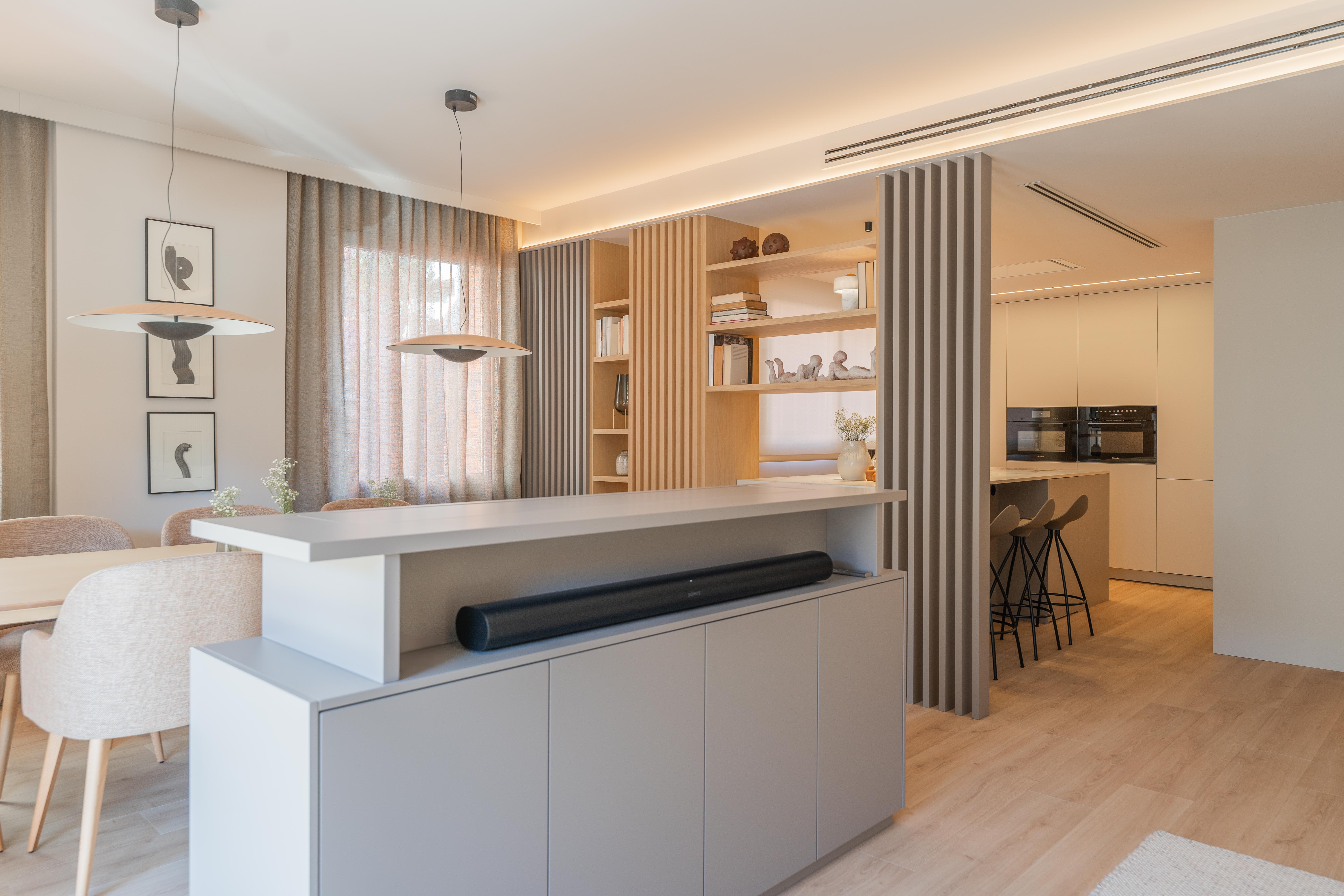 Zona moderna de salón y comedor con separadores de listones de madera y Mueble para TV ocultable