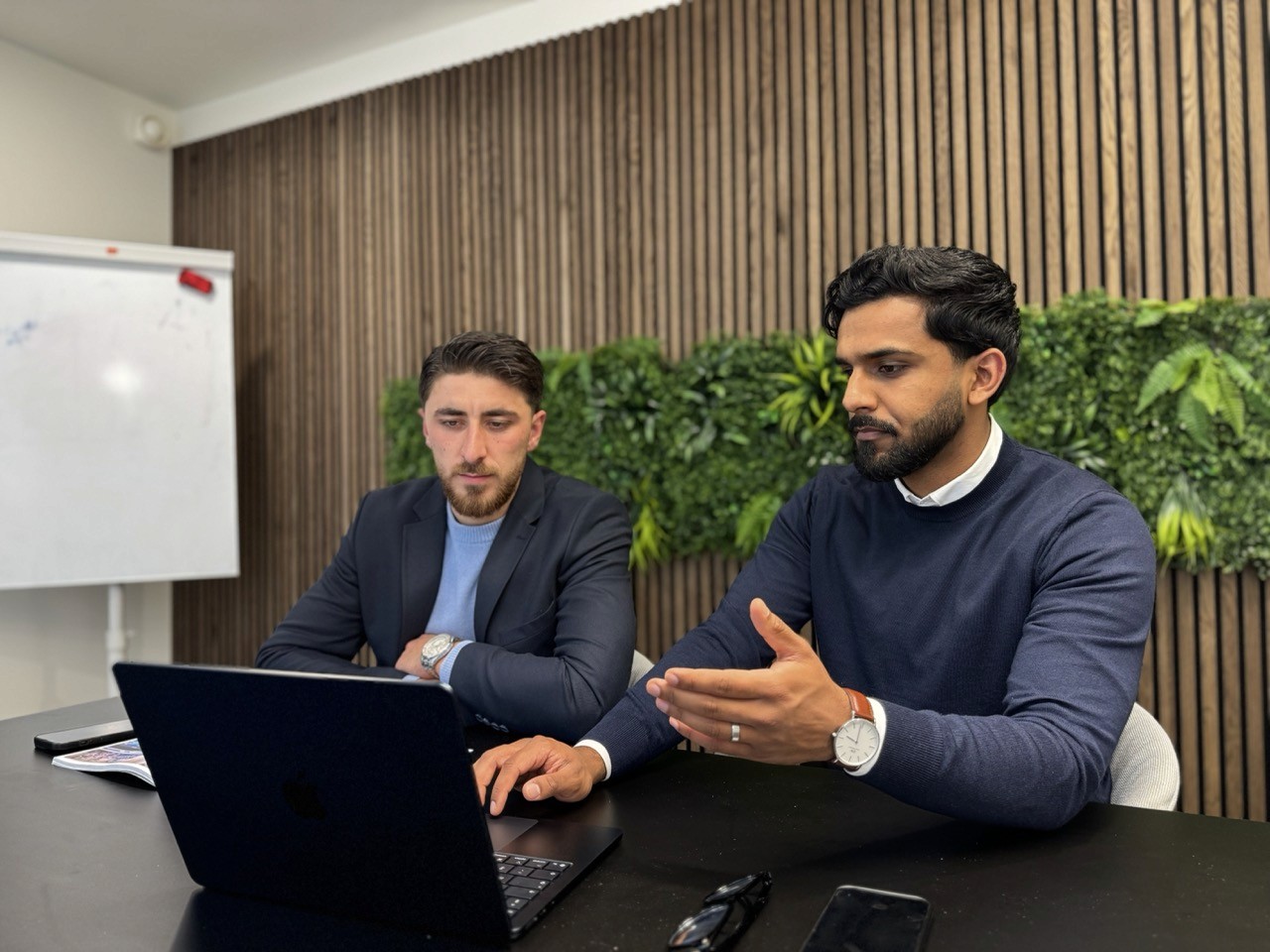 Adviseur en klant in gesprek in moderne kantooromgeving – kennismakingsgesprek