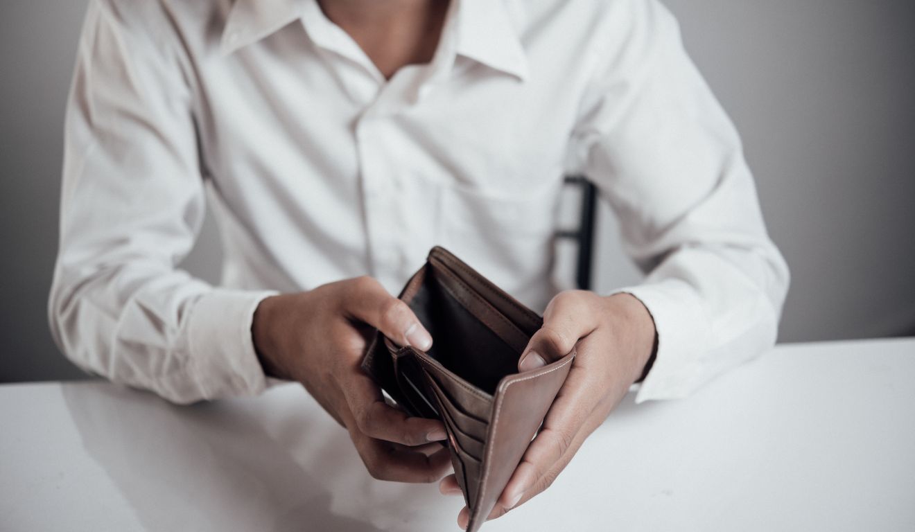 Pessoa abrindo carteira vazia sem dinheiro