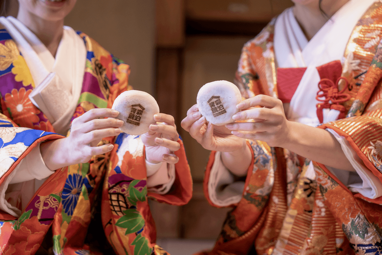 Two girls holding customised mochi at Aomori Kurahaku