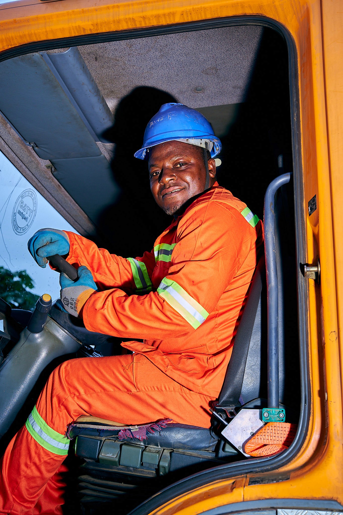 man in blue white and red plaid button up shirt wearing yellow hard hat holding black