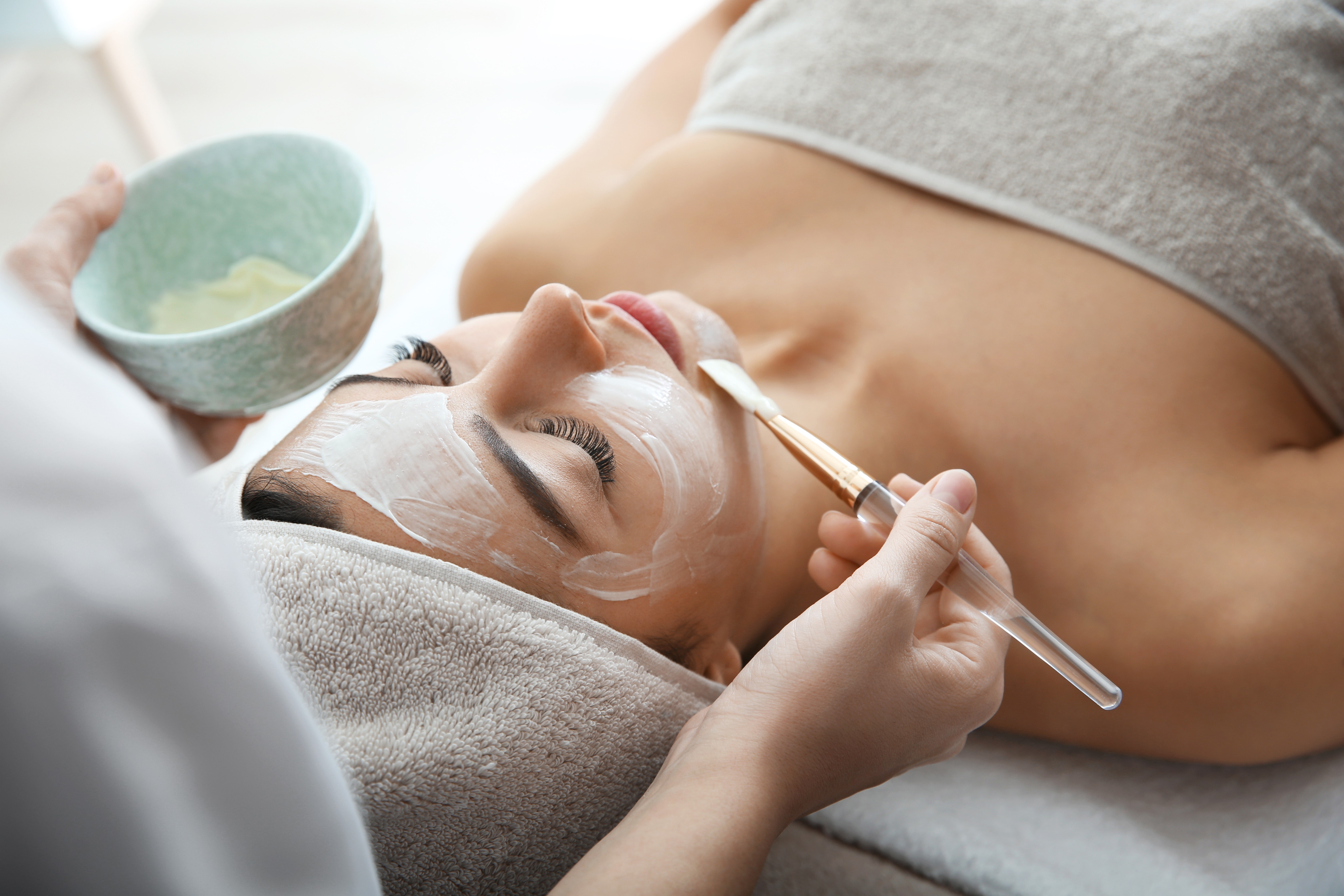 Client receiving a relaxing facial mask treatment during a premium head spa experience.